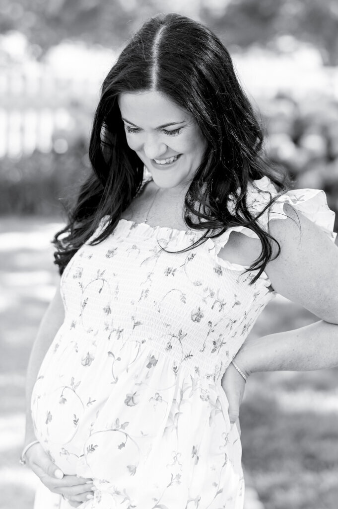 Black and white image of a pregnant woman holding her belly by Nashville maternity photographer Kristie Lloyd