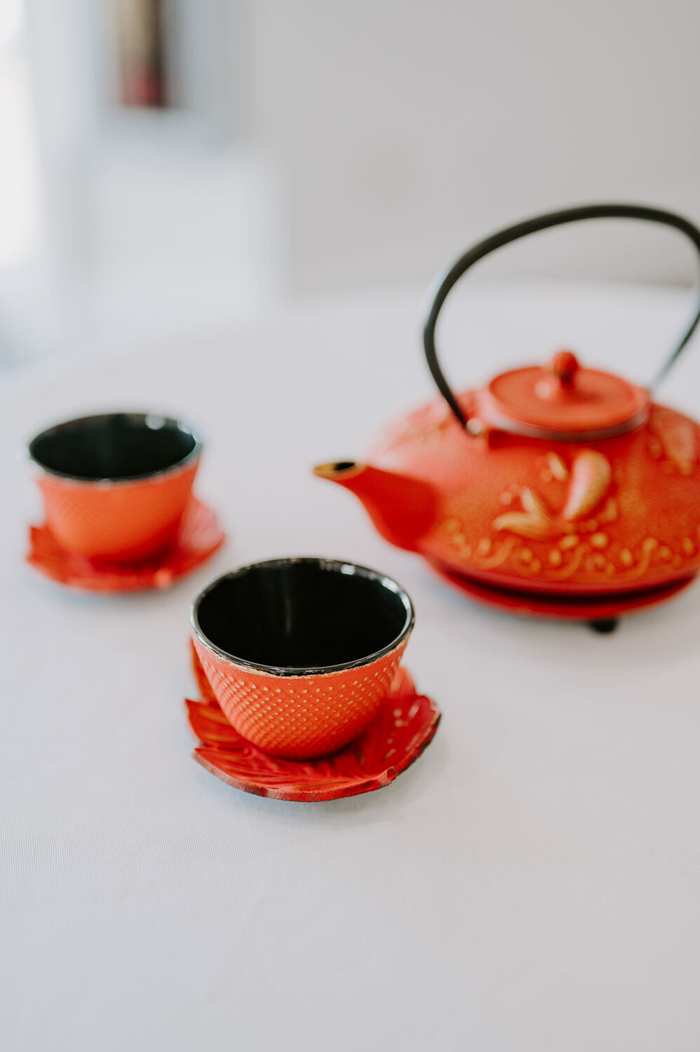 Red teapot with matching cups set on a table