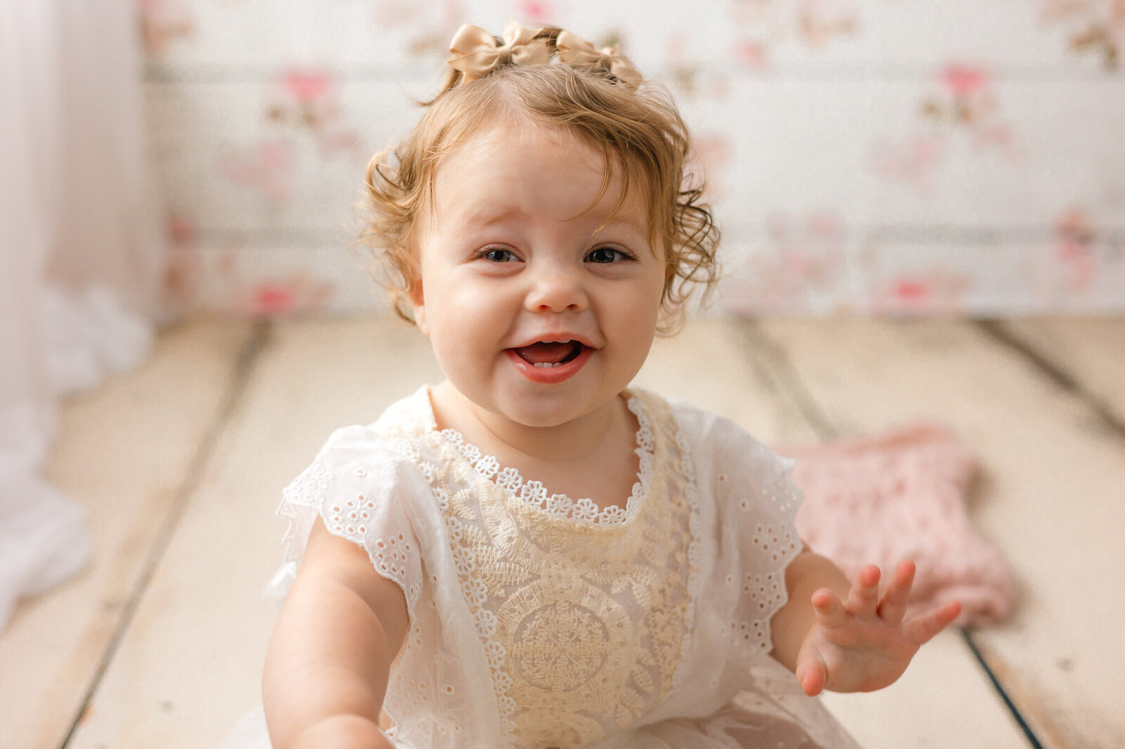 Little girl smiling in front of floral backdrop with Constance Calton Photography
