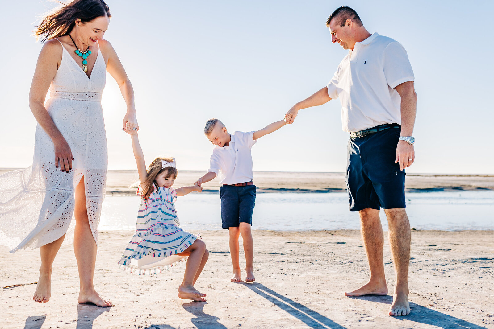 A playful beach photo with a mom, dad, little girl and boy on Fort Desoto North Beach In  St. Pete