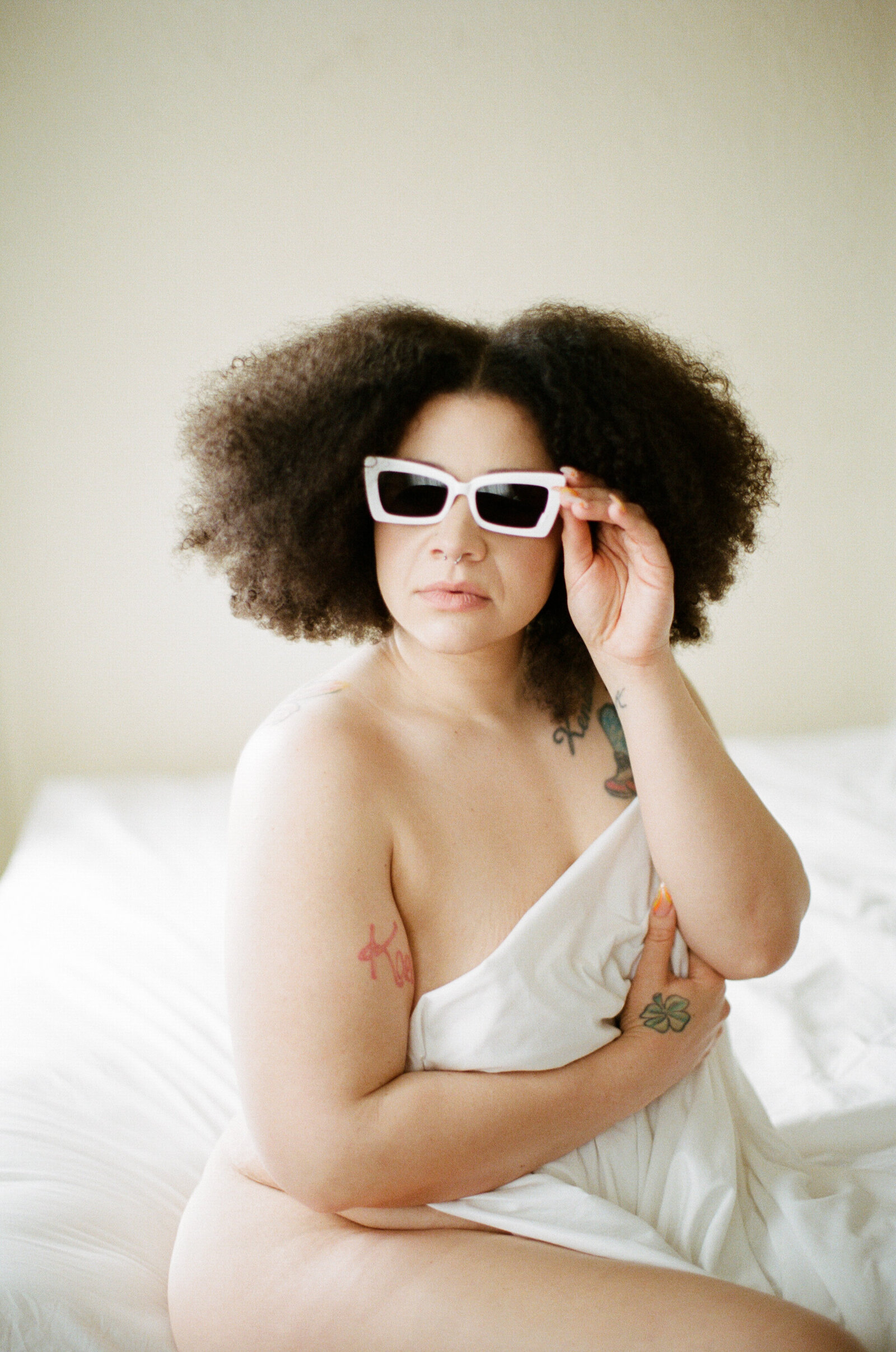 Woman wrapped in sheets wearing sunglasses