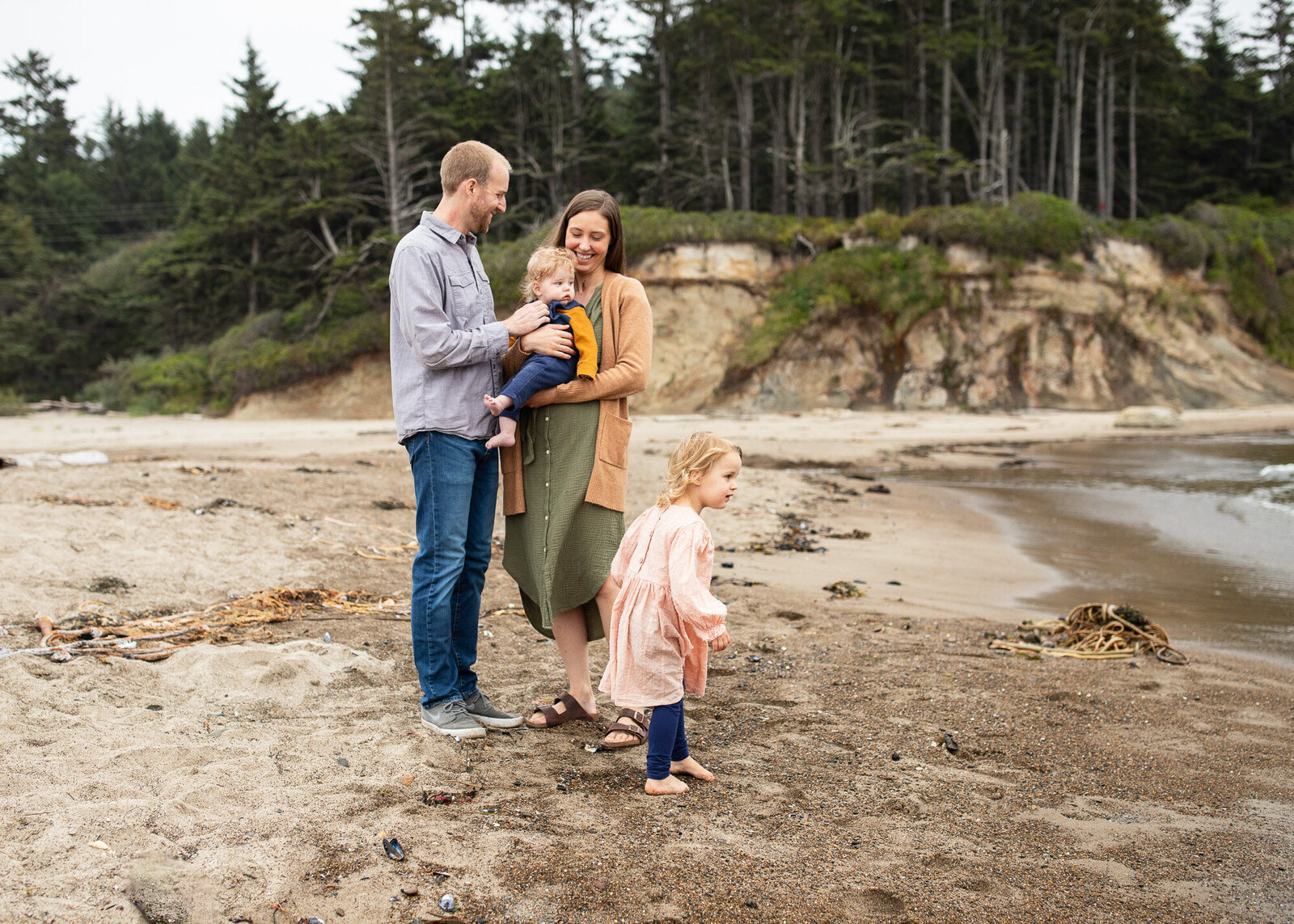 family of four playing on beach with small children at Oregon coast. Photo by Portland family photographer.