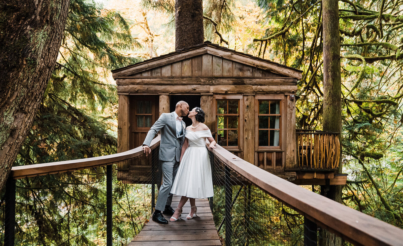 A couple kisses in front of a treehouse at Washington's Treehouse Point photographed by Amy Galbraith