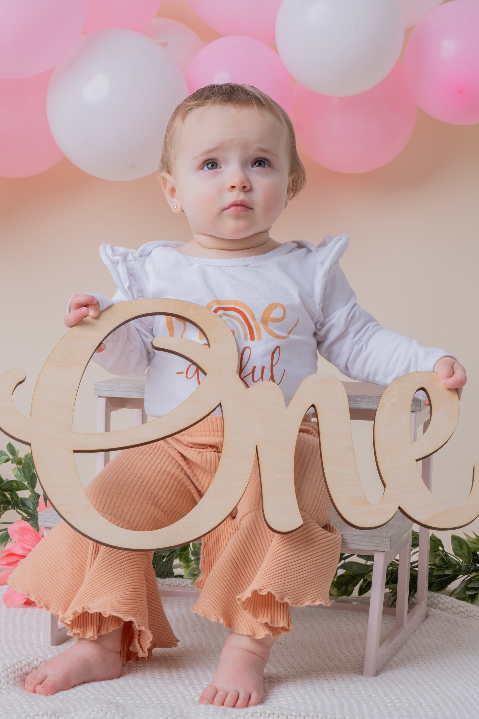 One year old milestone session in studio holding sign