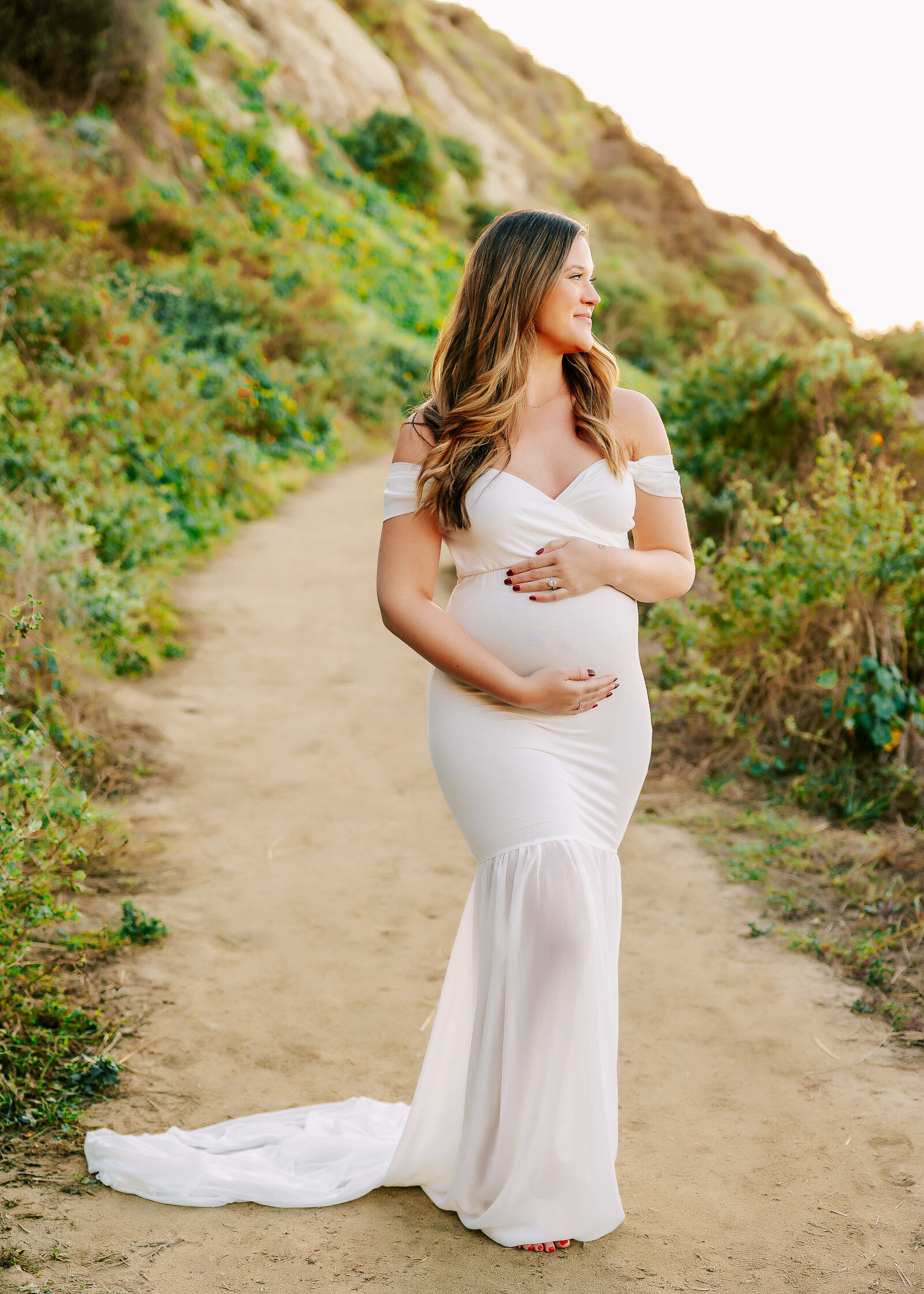 Expectant mom gazing out at ocean at maternity session in Los Angeles.