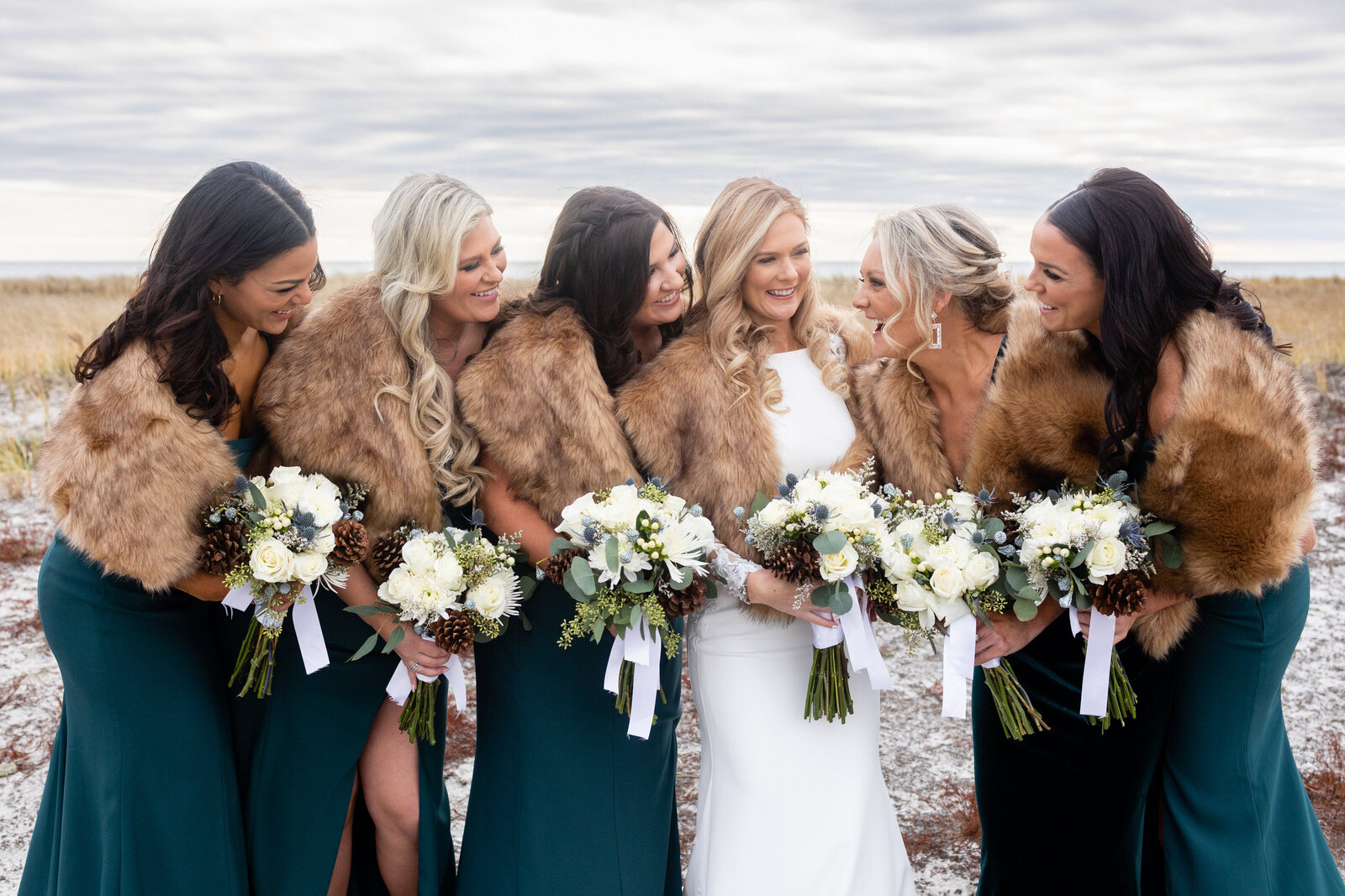 bride and bridesmaids with flowers at winter wedding wychmere