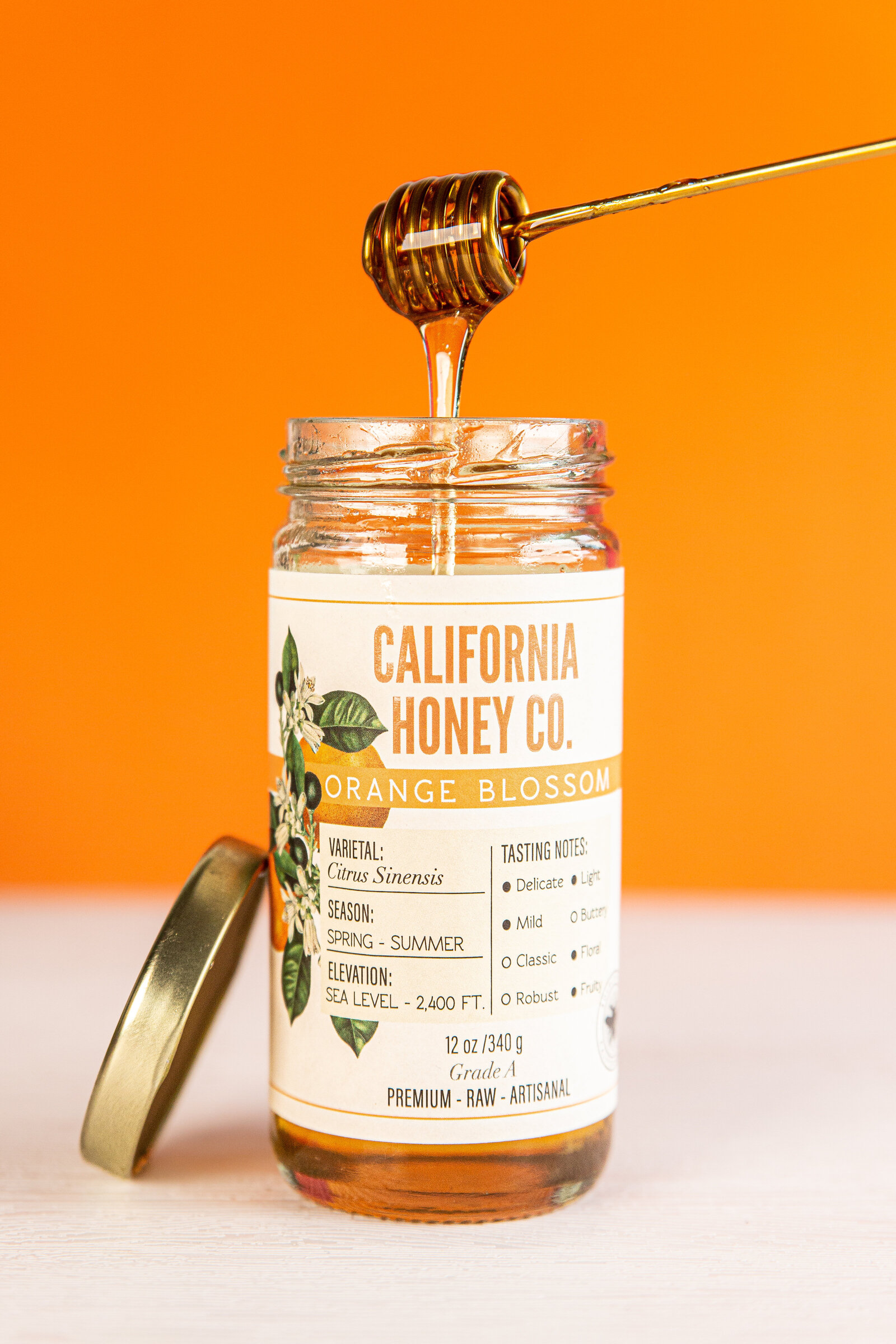 Chelsea Loren styled honey product photography with orange backdrop for Orange Blossom California Honey Co.