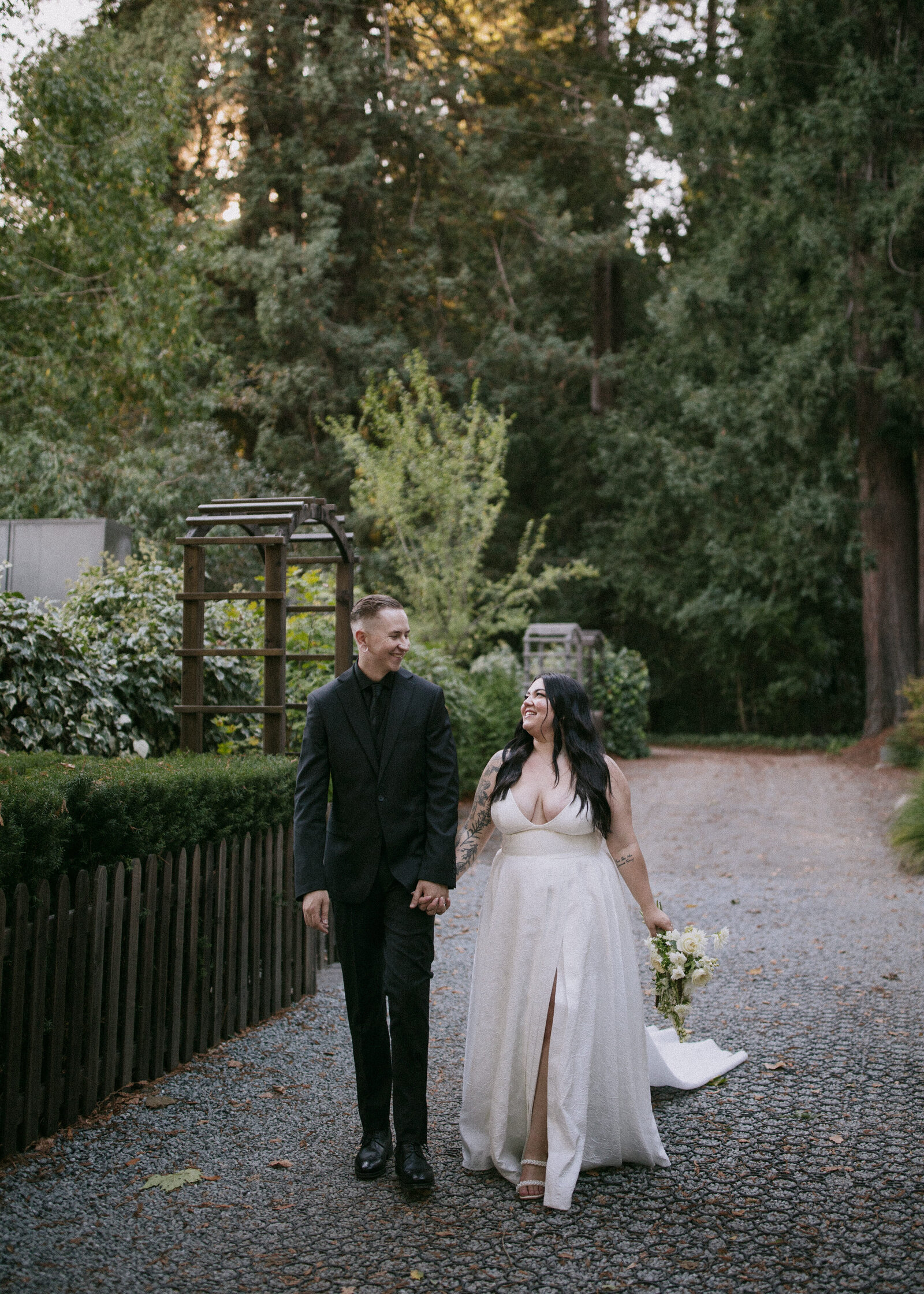 Bride and groom walk through redwoods taken by wedding photographer Northern California
