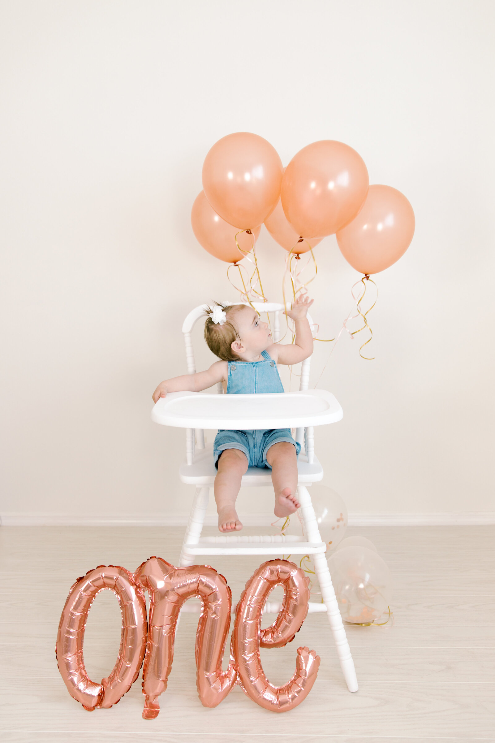 kid looking at balloons with one year balloon by spokane wa family photographer