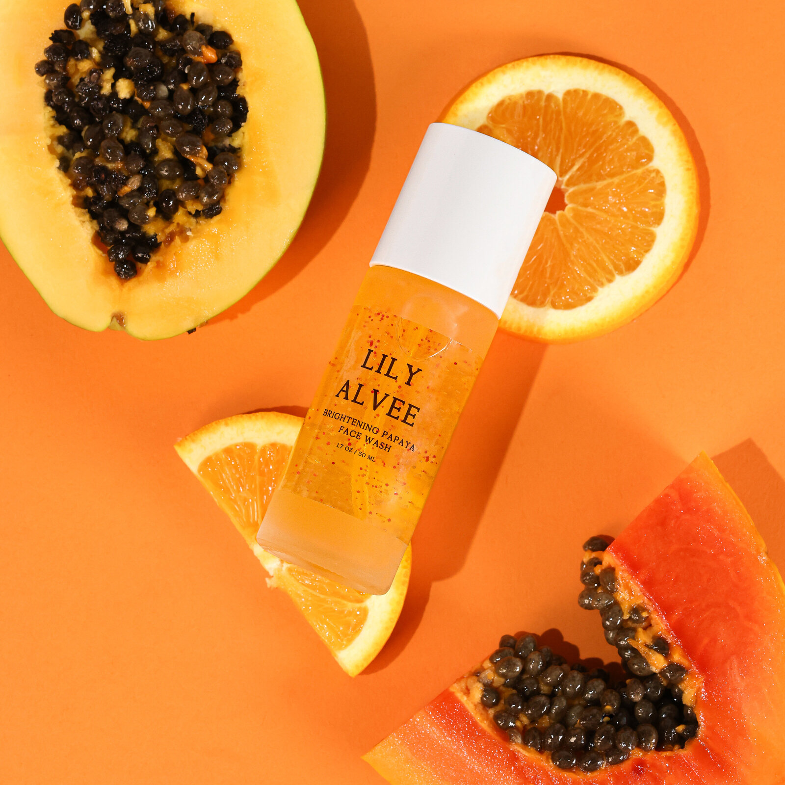 Vibrant skincare product photography featuring papaya and orange by commercial product photographer Chelsea Loren