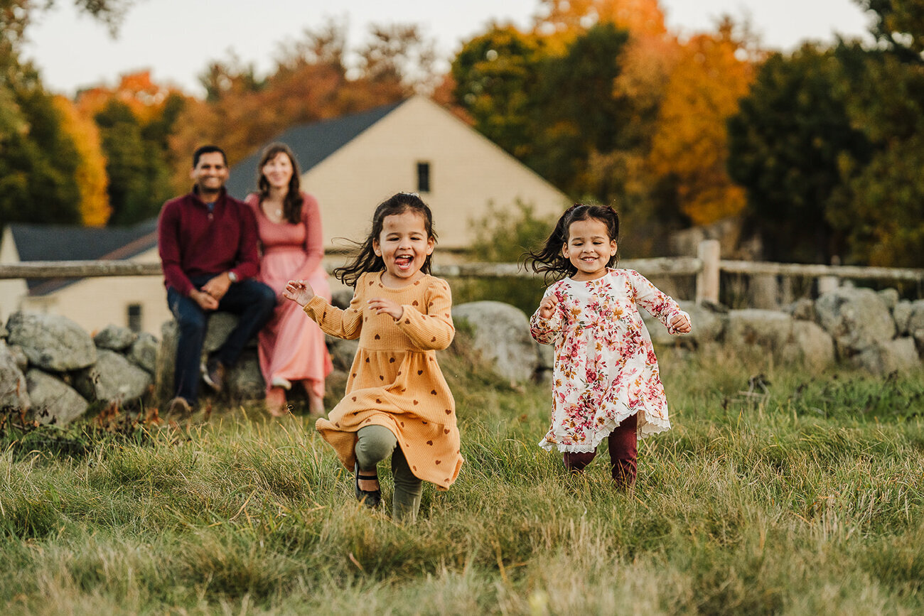 toddler girls run towards camera laughing for autumn boston family photos