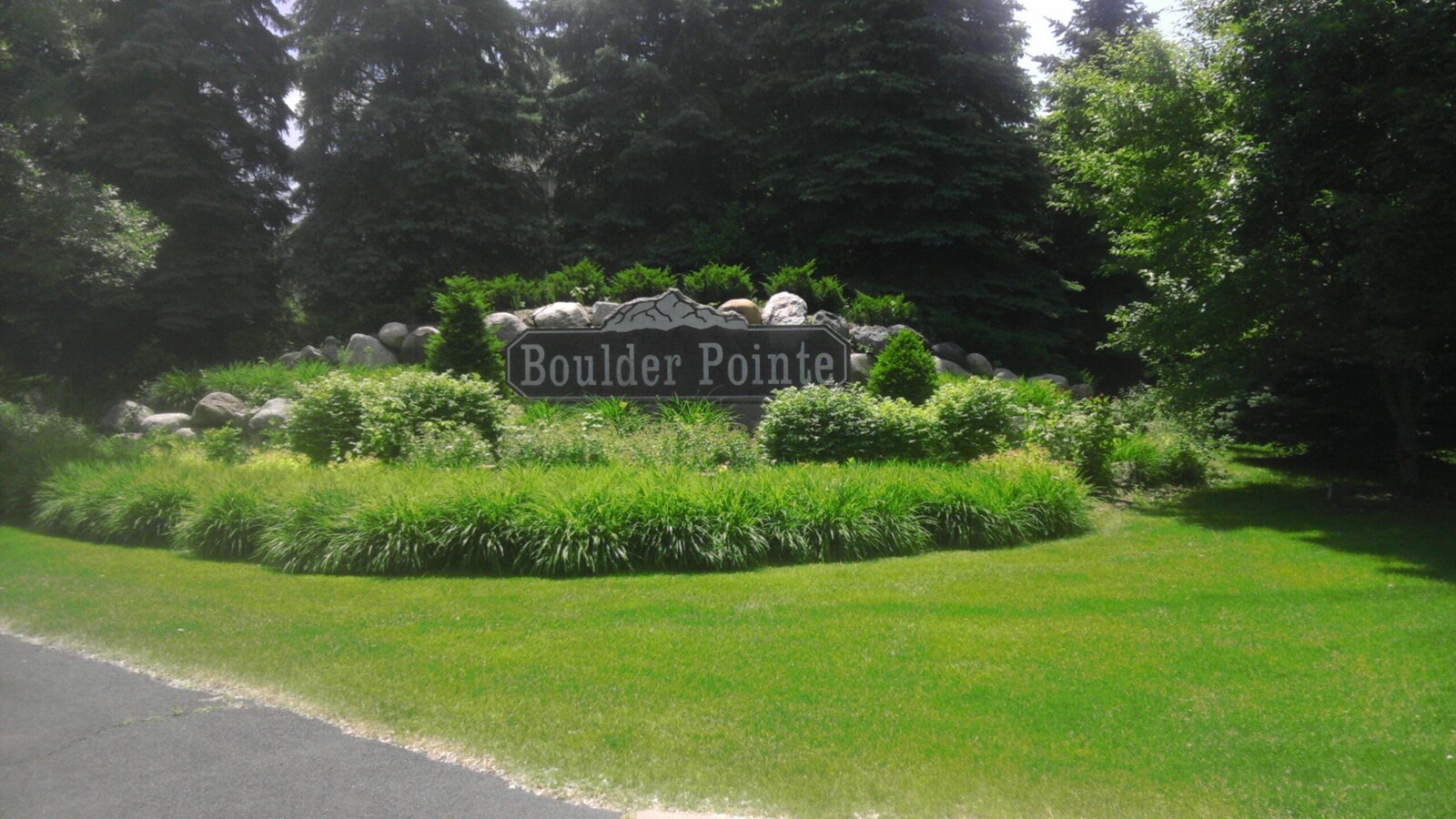 Commercial landscaping around boulder pointe sign with vairous green shrubery