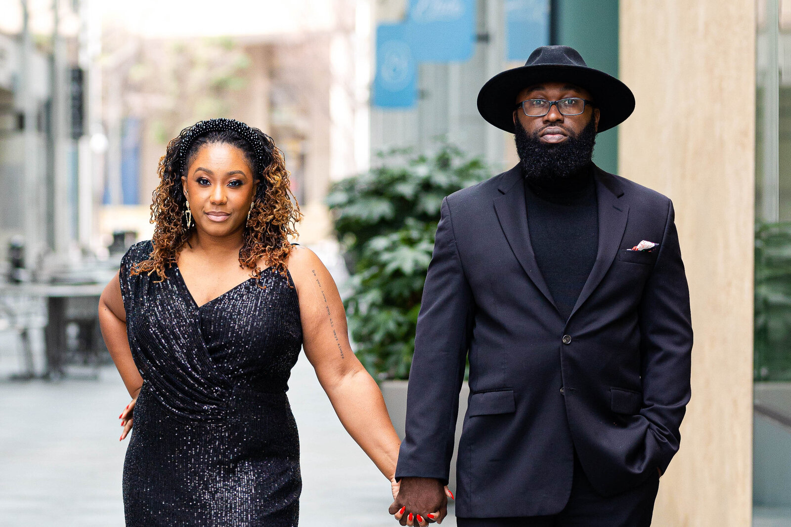 Formal dressed black couple holding hands at engagement session