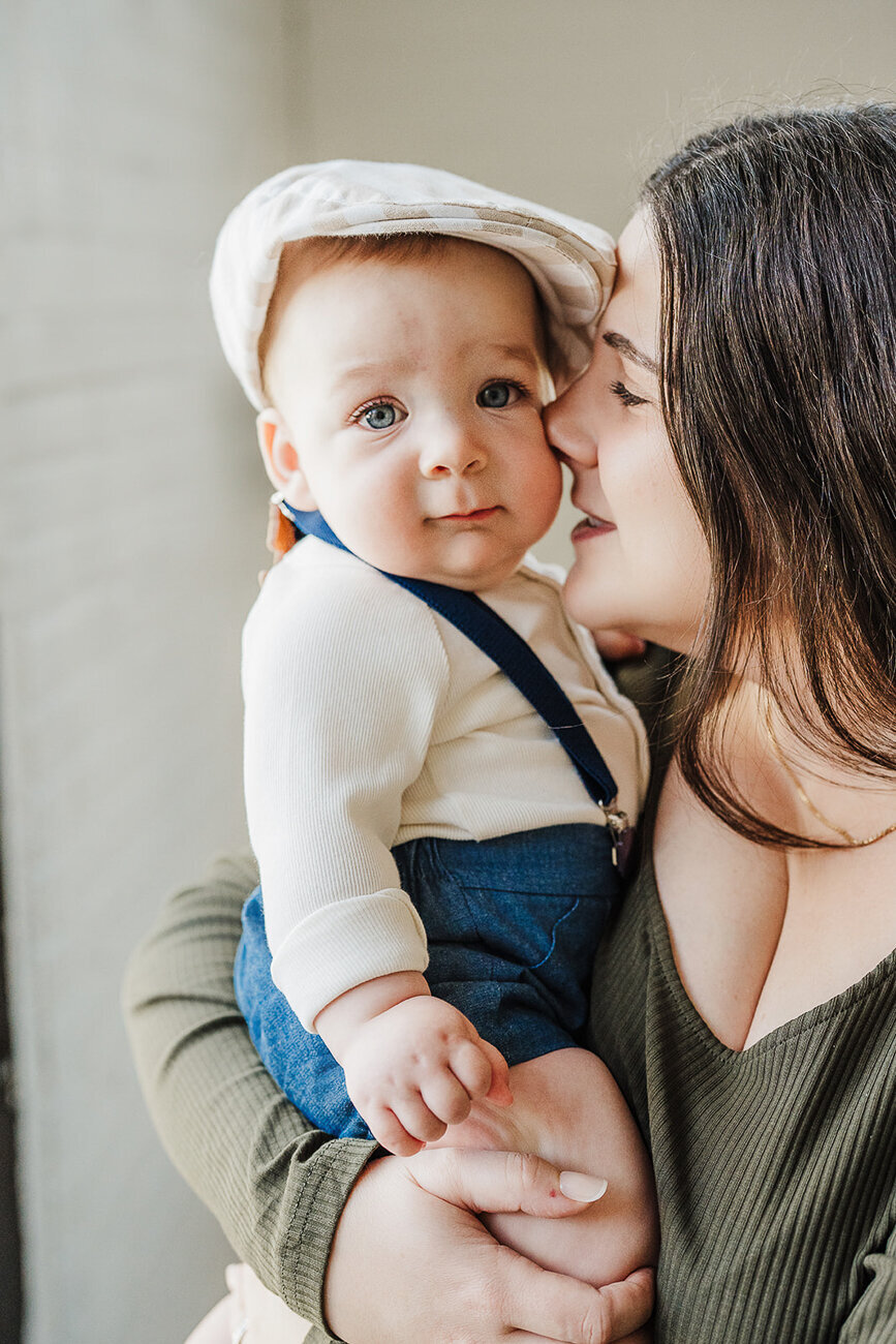 mom snuggles her nose to baby sons cheek during boston family photo session