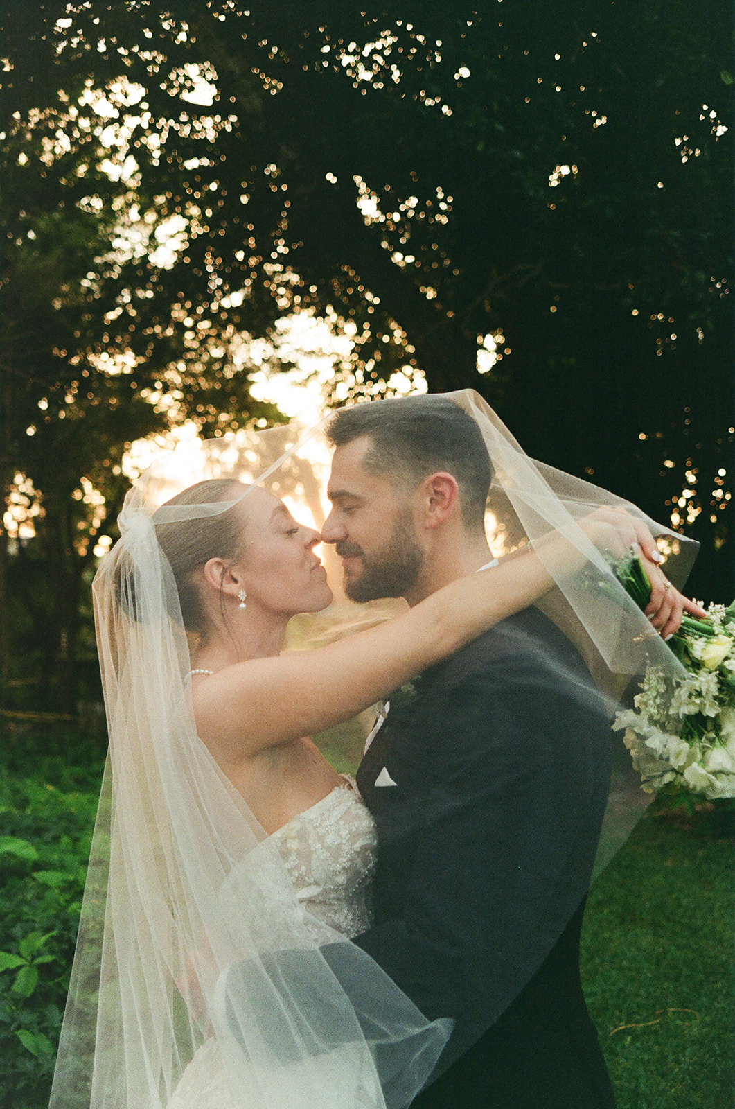 Bride covers groom in veil outdoors during documentary wedding photography session | Sush Digital Media