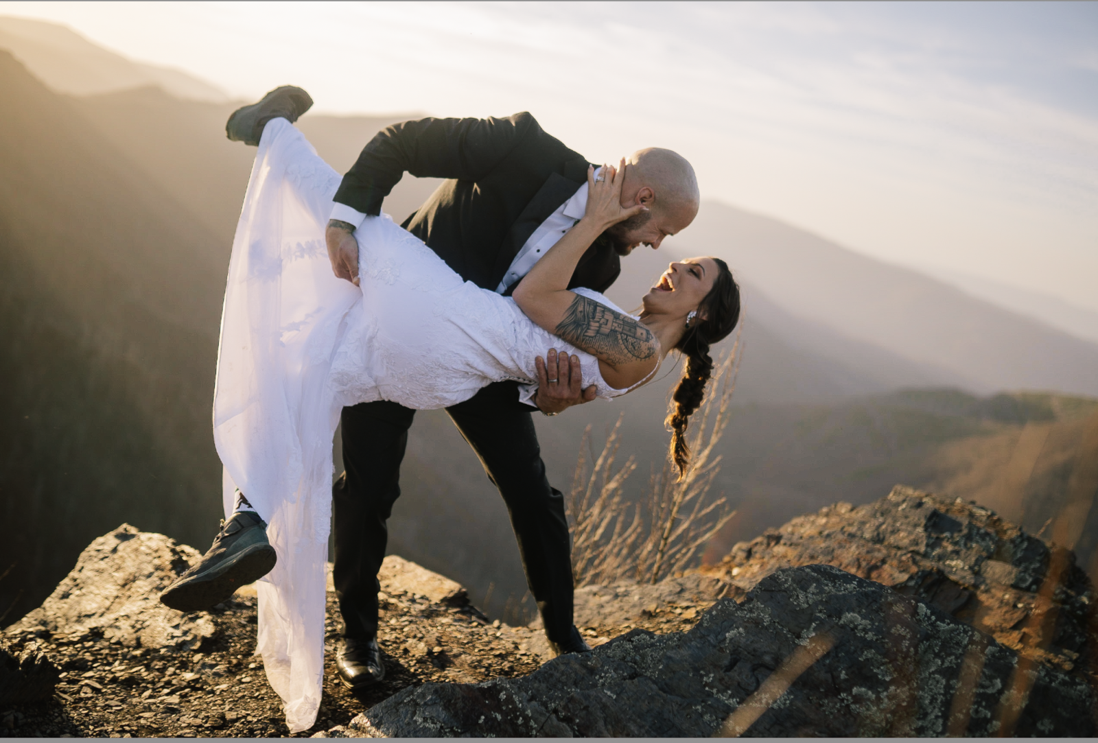 Lake Tahoe wedding photographer capture groom lifting bride on mountaintop  after Lake Tahoe wedding