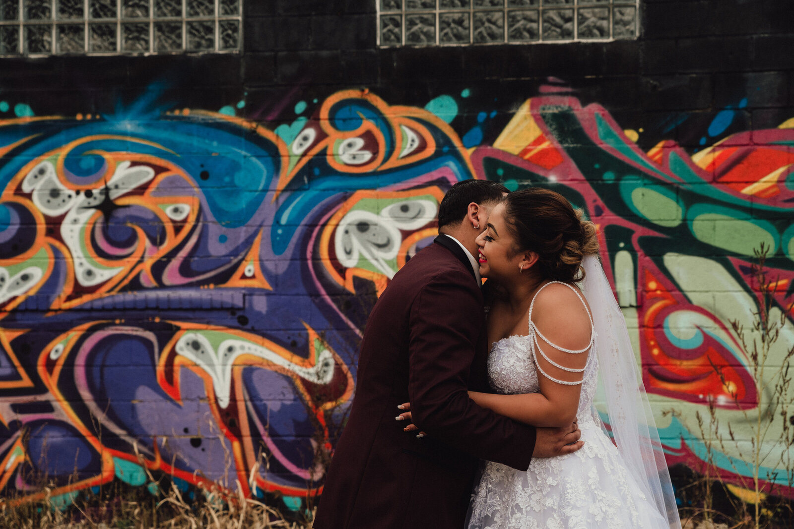 Partners stand in front of Cleveland graffiti on their wedding day.