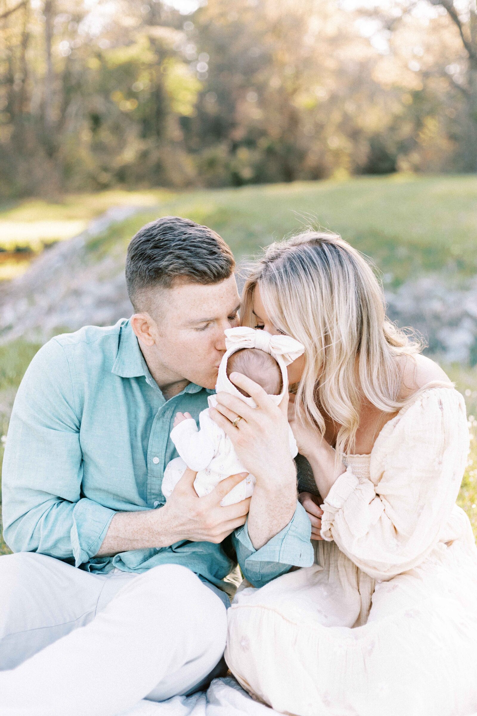 parents kissing newborn in baby photos in peoria illinois
