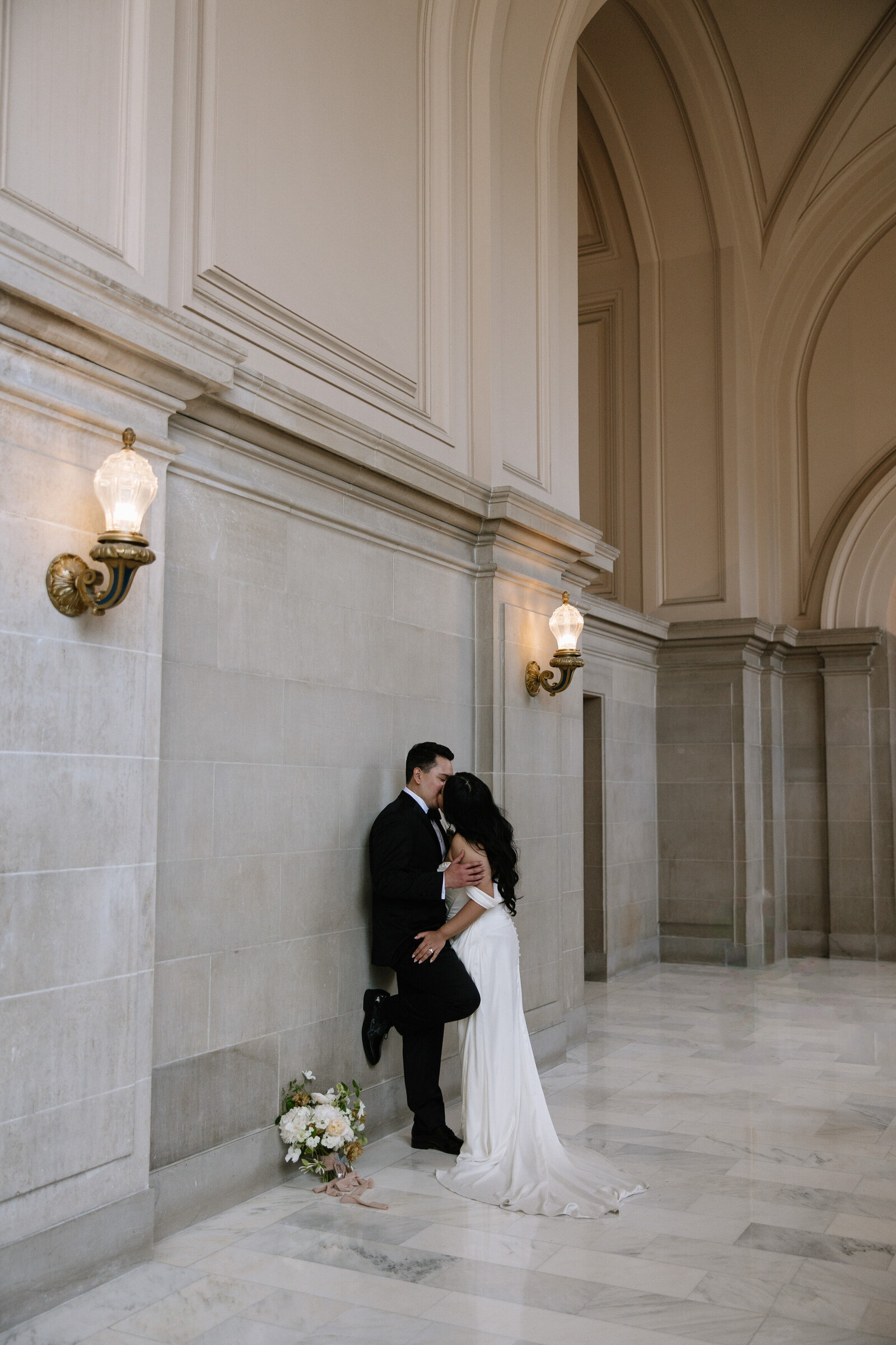 Bride and groom kiss for bridal portraits in City Hall by Northern California wedding photographer, Erica Rochelle
