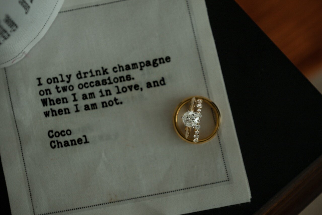 A detailed close-up of wedding rings resting on an whimsical napkin captured by CMH Studios during a San Antonio wedding