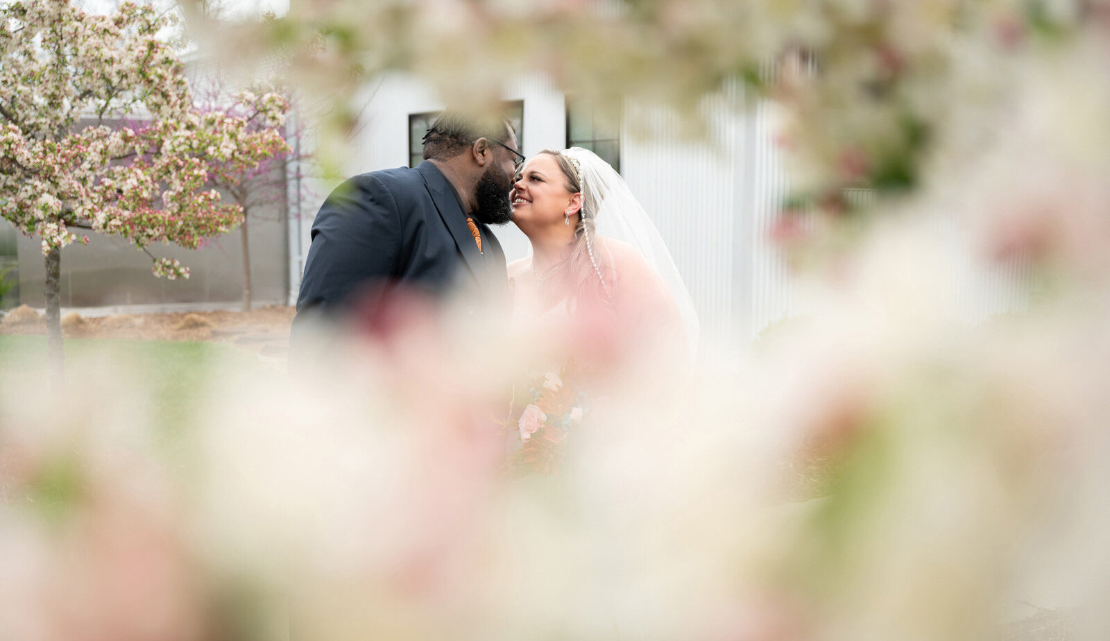bride and groom obscured by flower blossoms