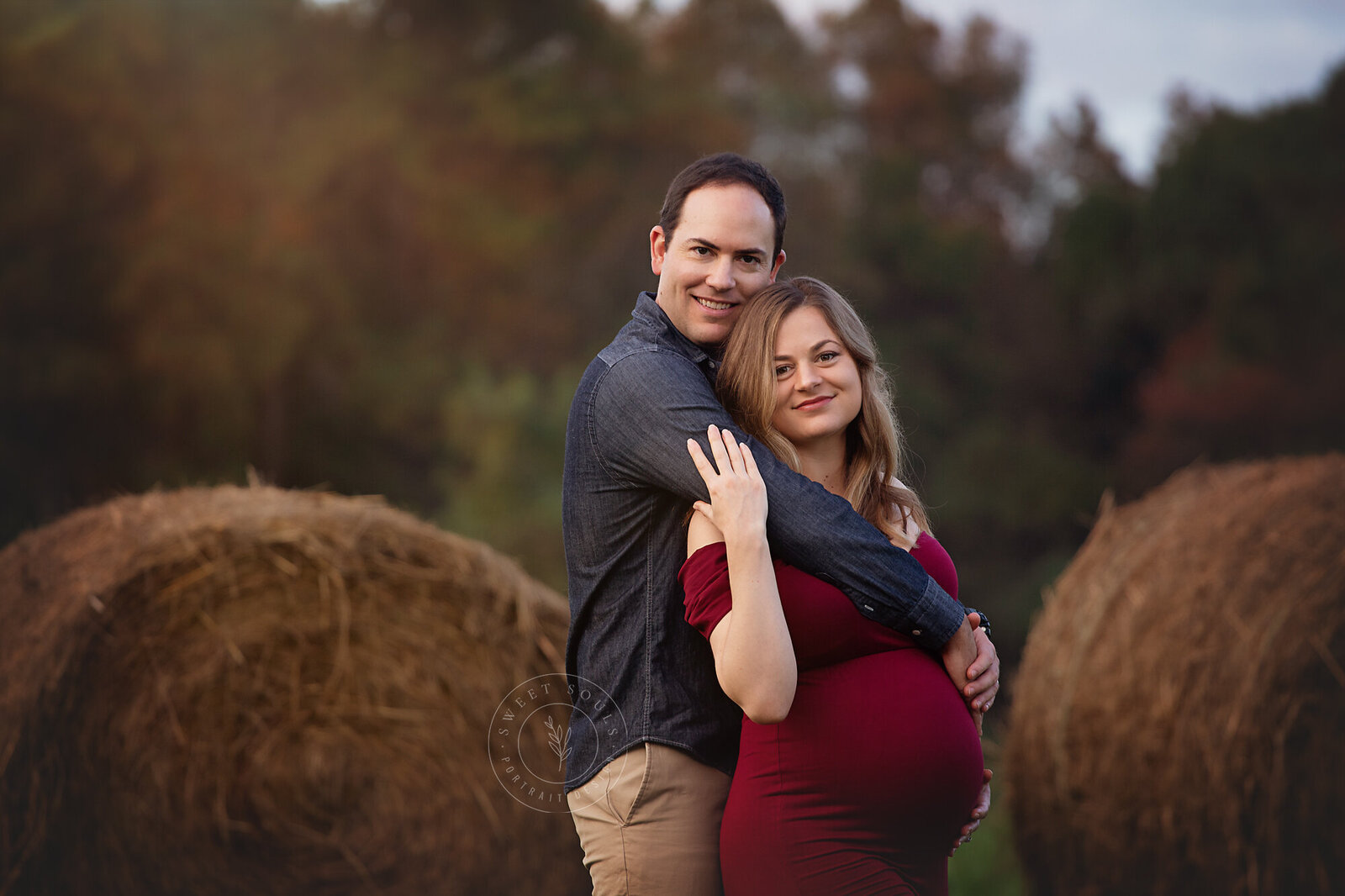couple in front of hay bales maternity session fisher farm park