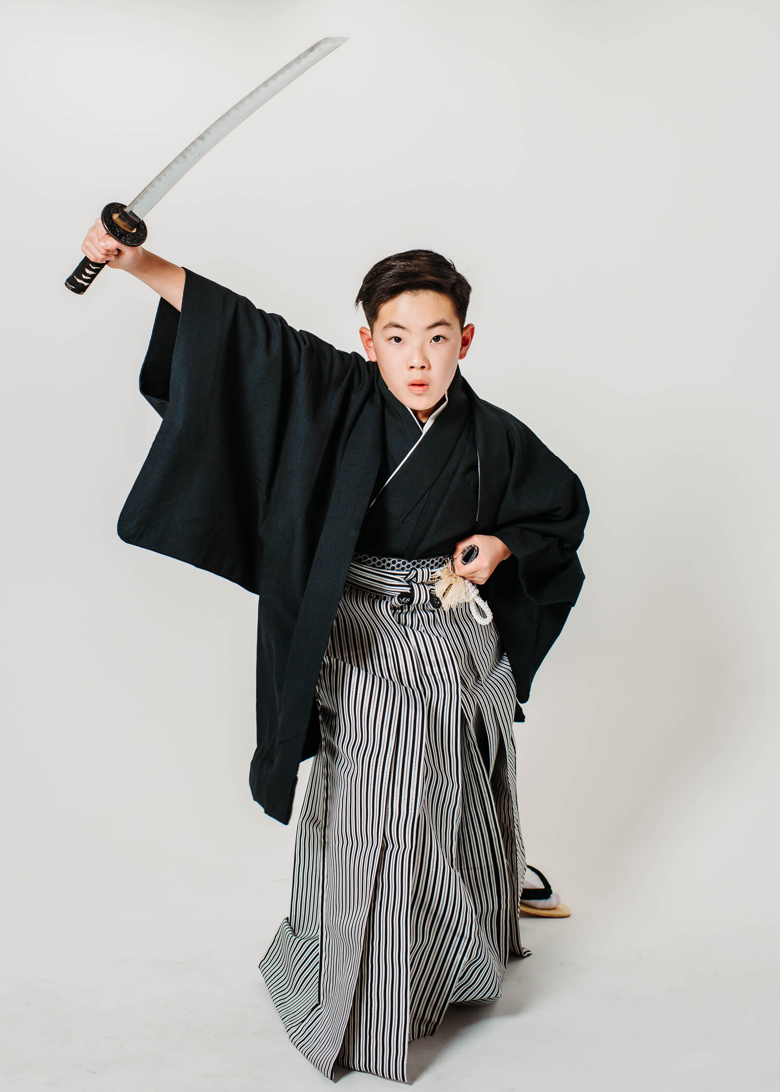 Boy in traditional black montsuki hakama posing with katana for graduation | 卒業式 紋付袴 男の子 日本刀 ポーズ