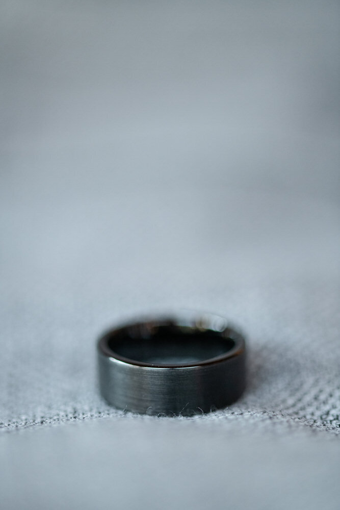 mens dark gray wedding band on gray fabric