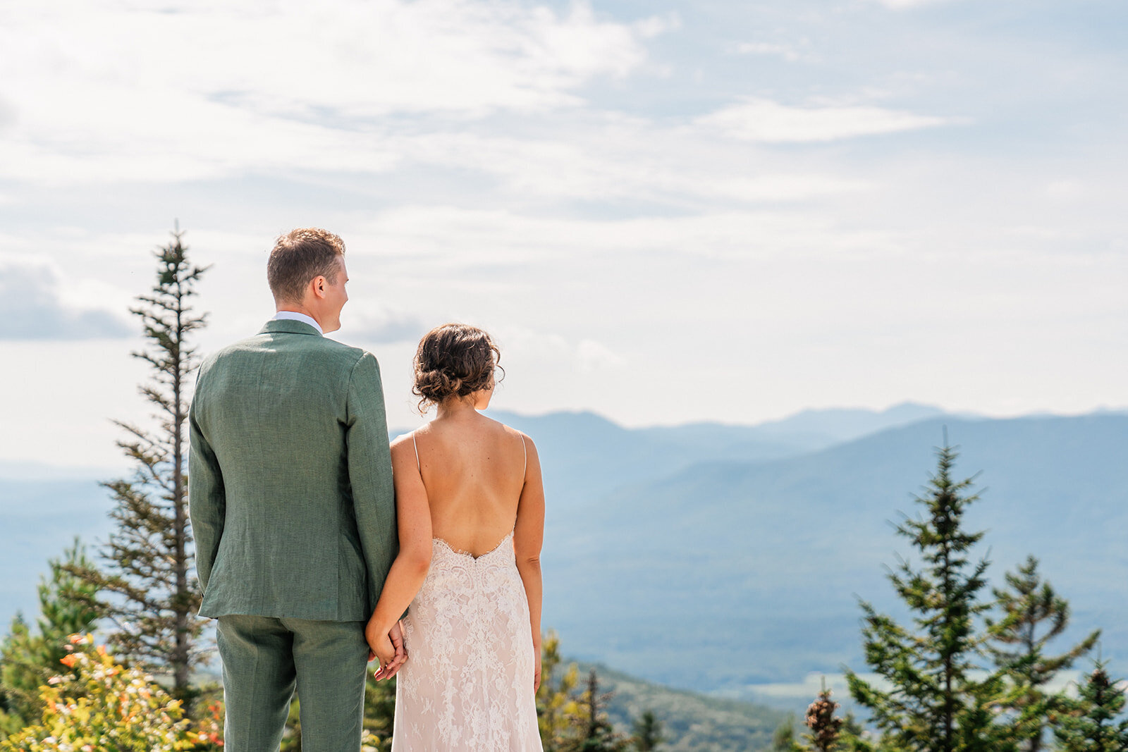 A couple standing on a Mountain in western Maine during their Maine elopement day.