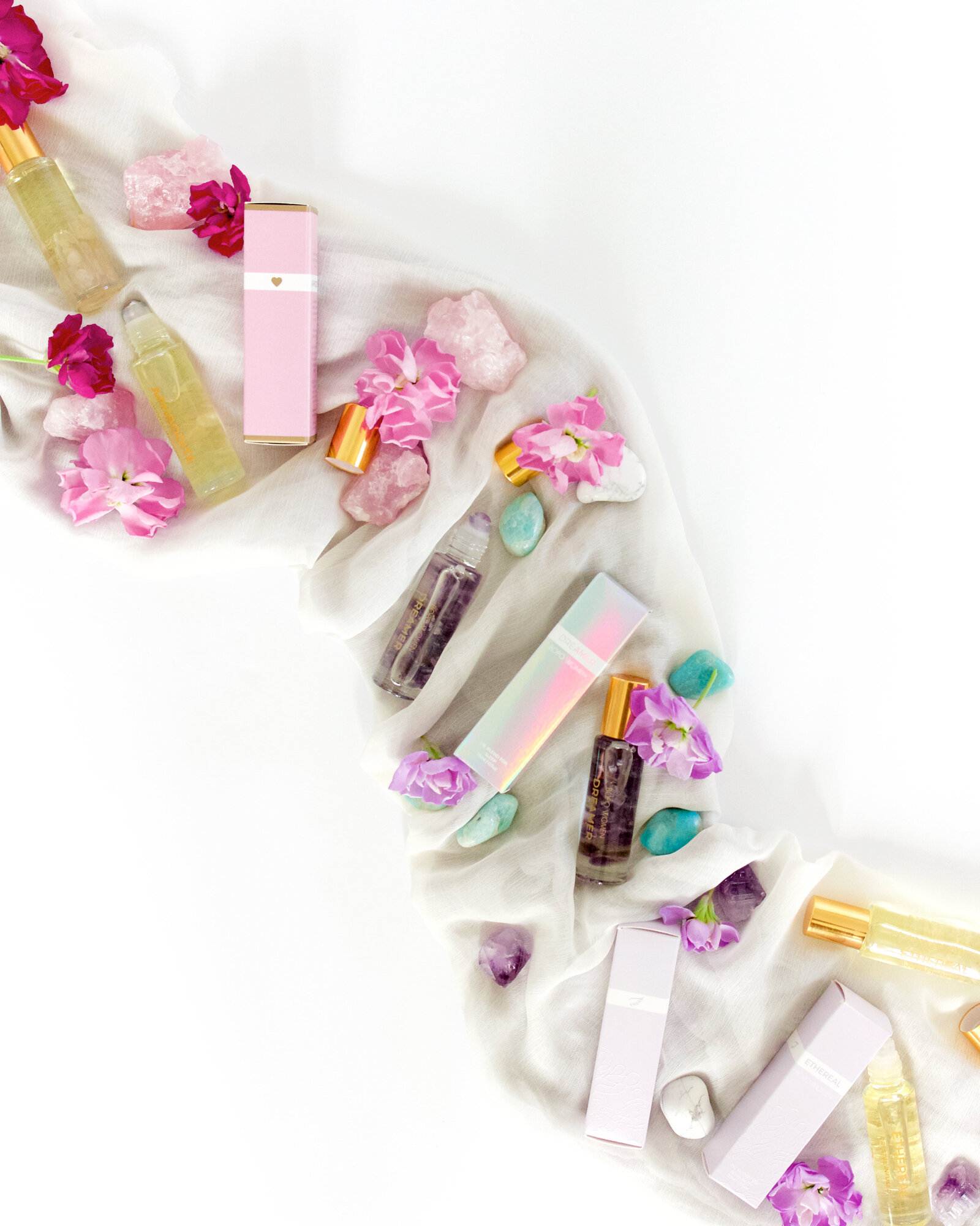 Feminine Floral luxe natural skincare product photography colorful crystals oil rollers