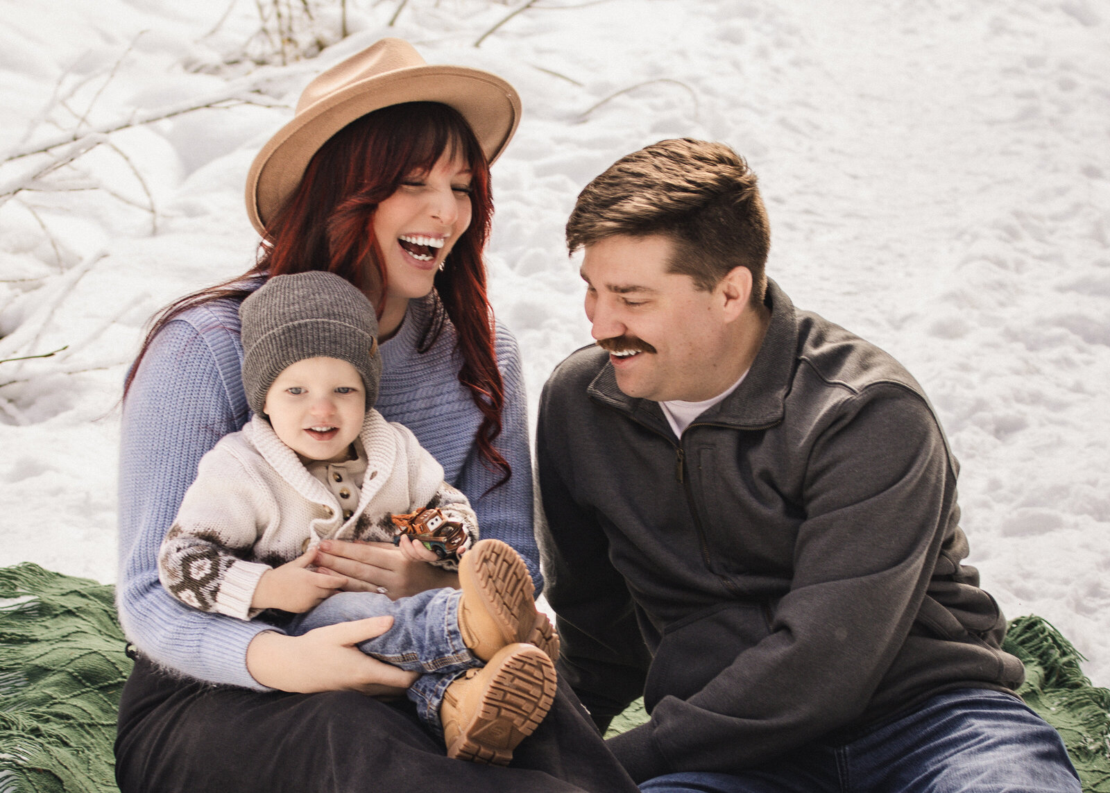 Family of three playing together in the snow on Mount Hood. 