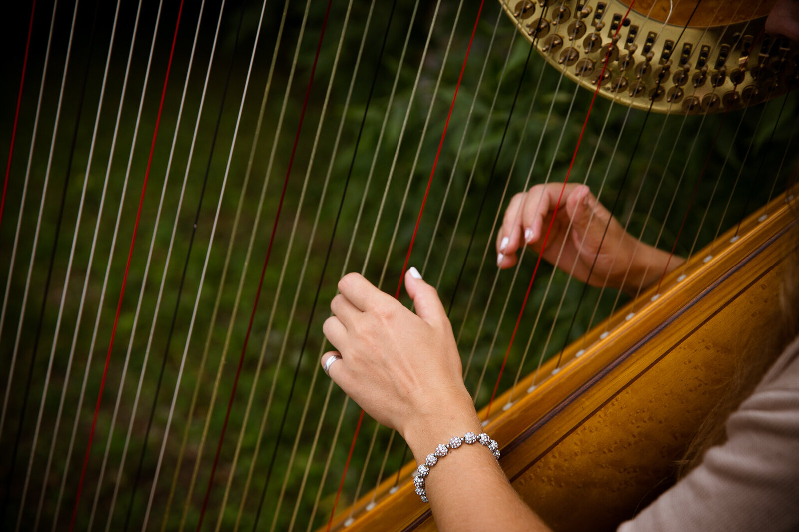Closeup of harp being played during wedding ceremony.