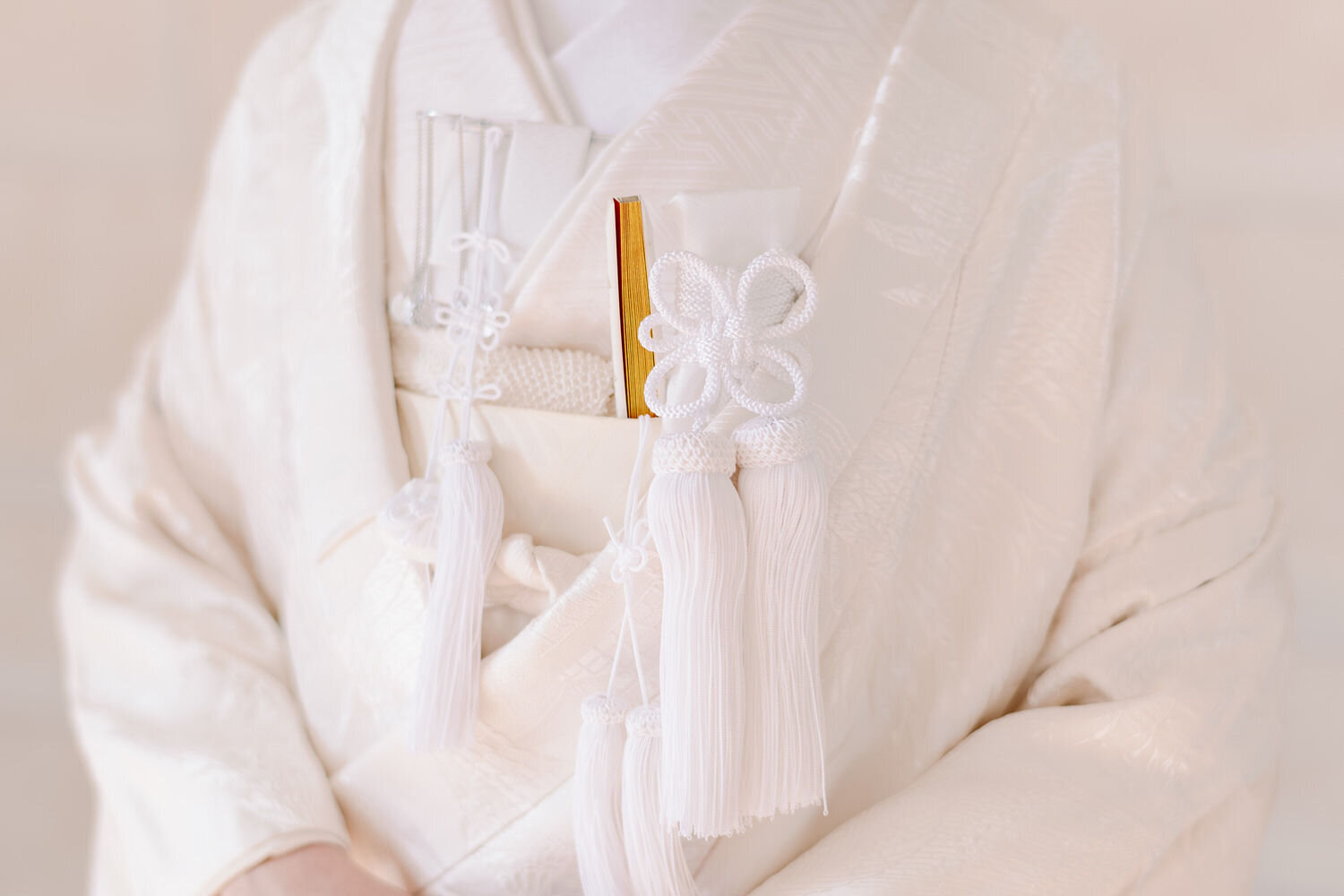 Close-up of pure white shiromuku wedding kimono tassels and intricate details, elegant Japanese bridal kimono rental Los Angeles California | 白無垢のタッセルと繊細なディテールのクローズアップ。ロサンゼルス カリフォルニアでのエレガントな着物レンタル和装ウェディング。