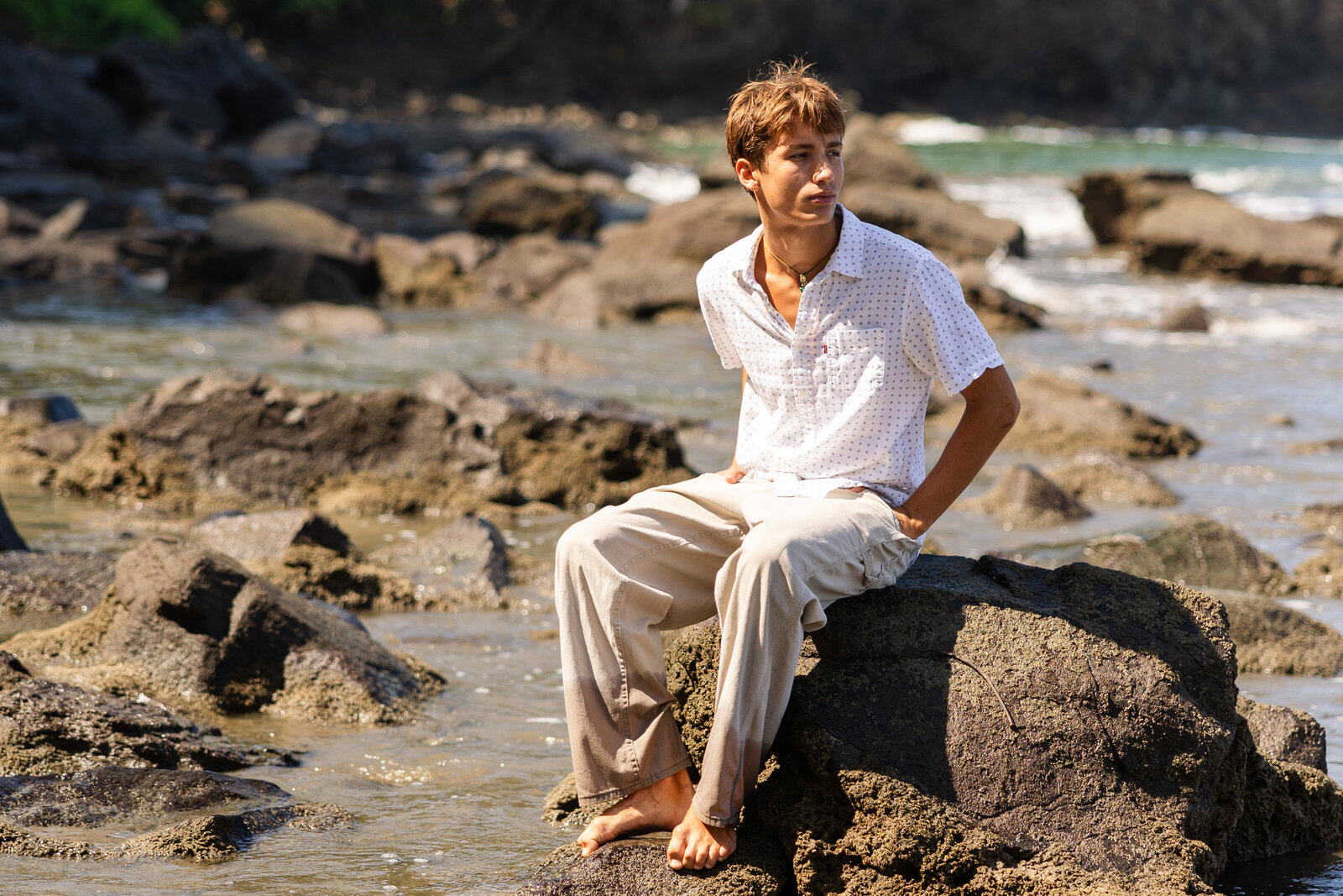 Portrait of man sitting on the shoreline of beach