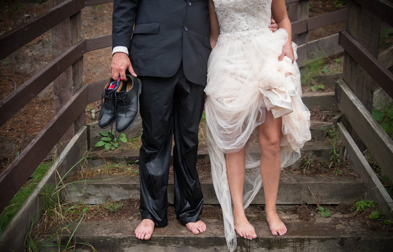 bride and groom in wet clothes on steps showing only their legs