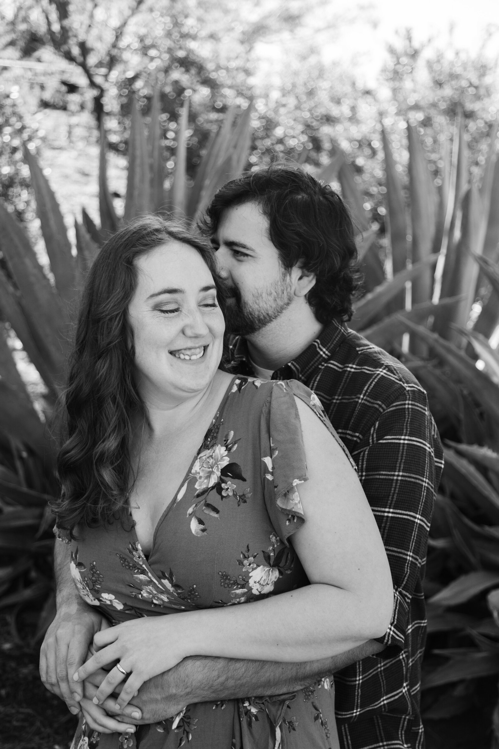 An engaged couple poses for photos in a garden in Los Angeles, Ca.