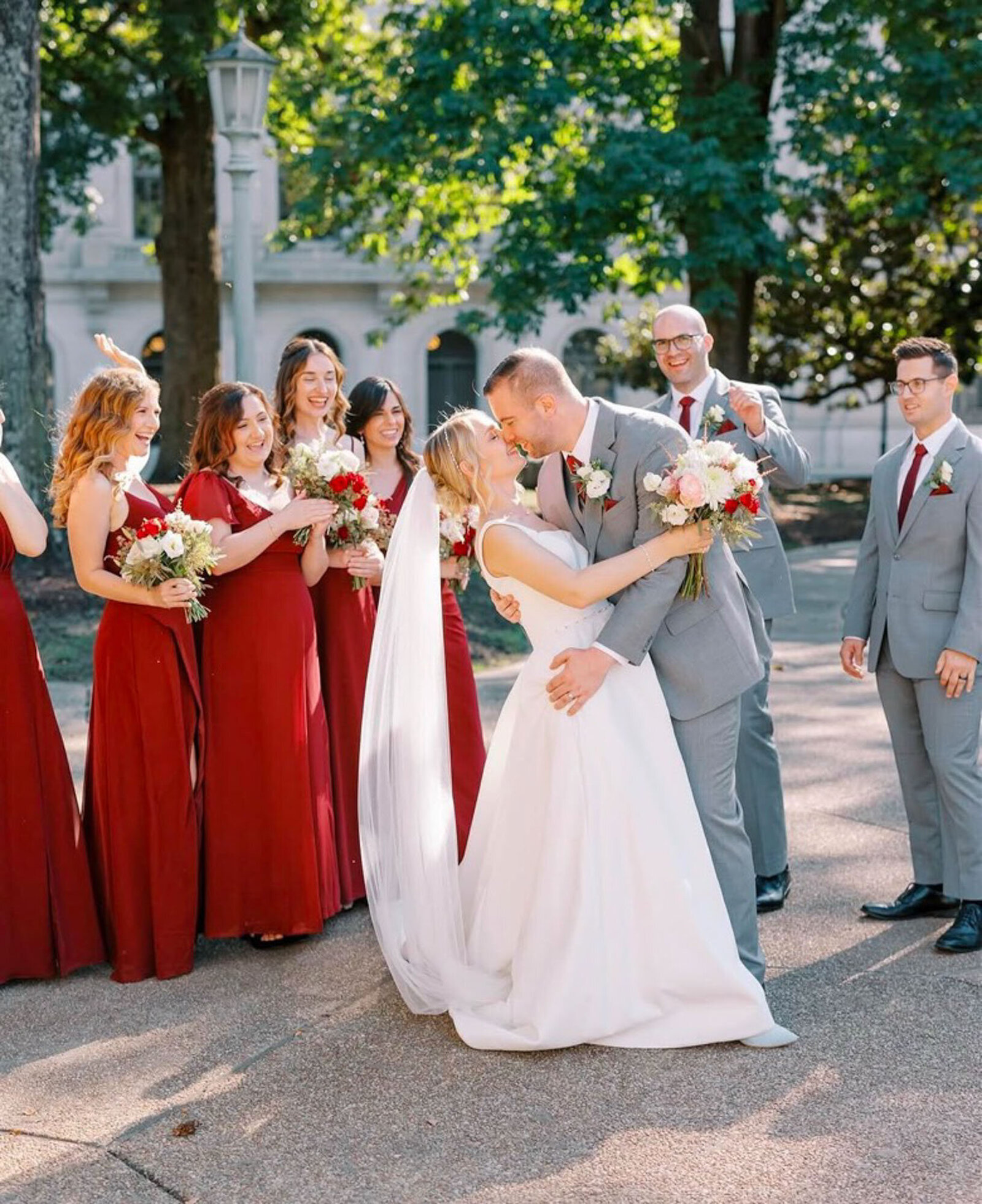 Kissing couple with bridal party around them at North Carolina destination wedding