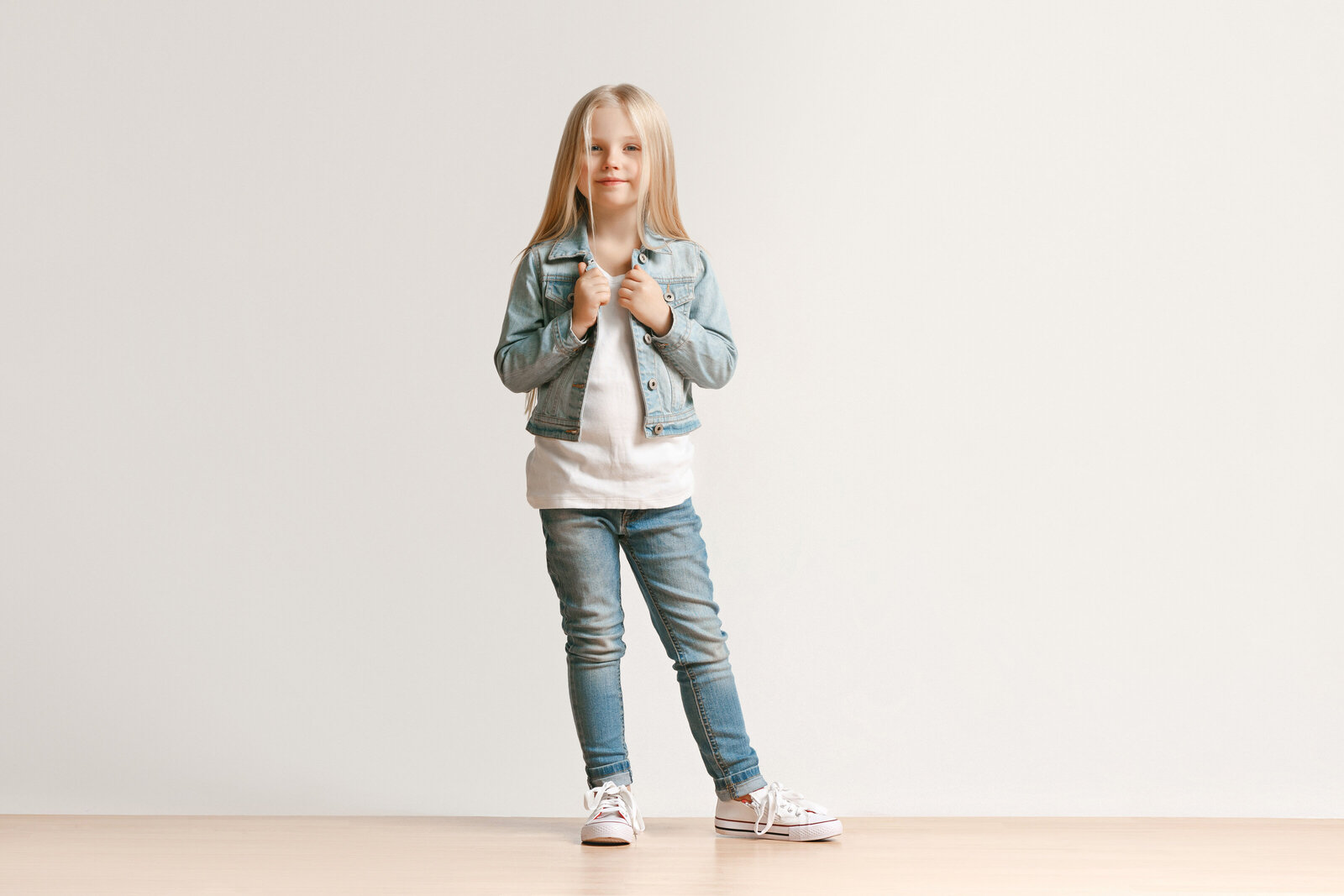full-length-portrait-cute-little-kid-girl-stylish-jeans-clothes-looking-camera-smiling-standing-against-white-studio-wall-kids-fashion-concept