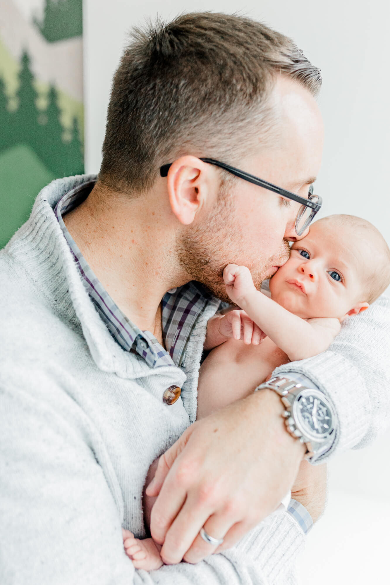 Boston dad kissing his newborn