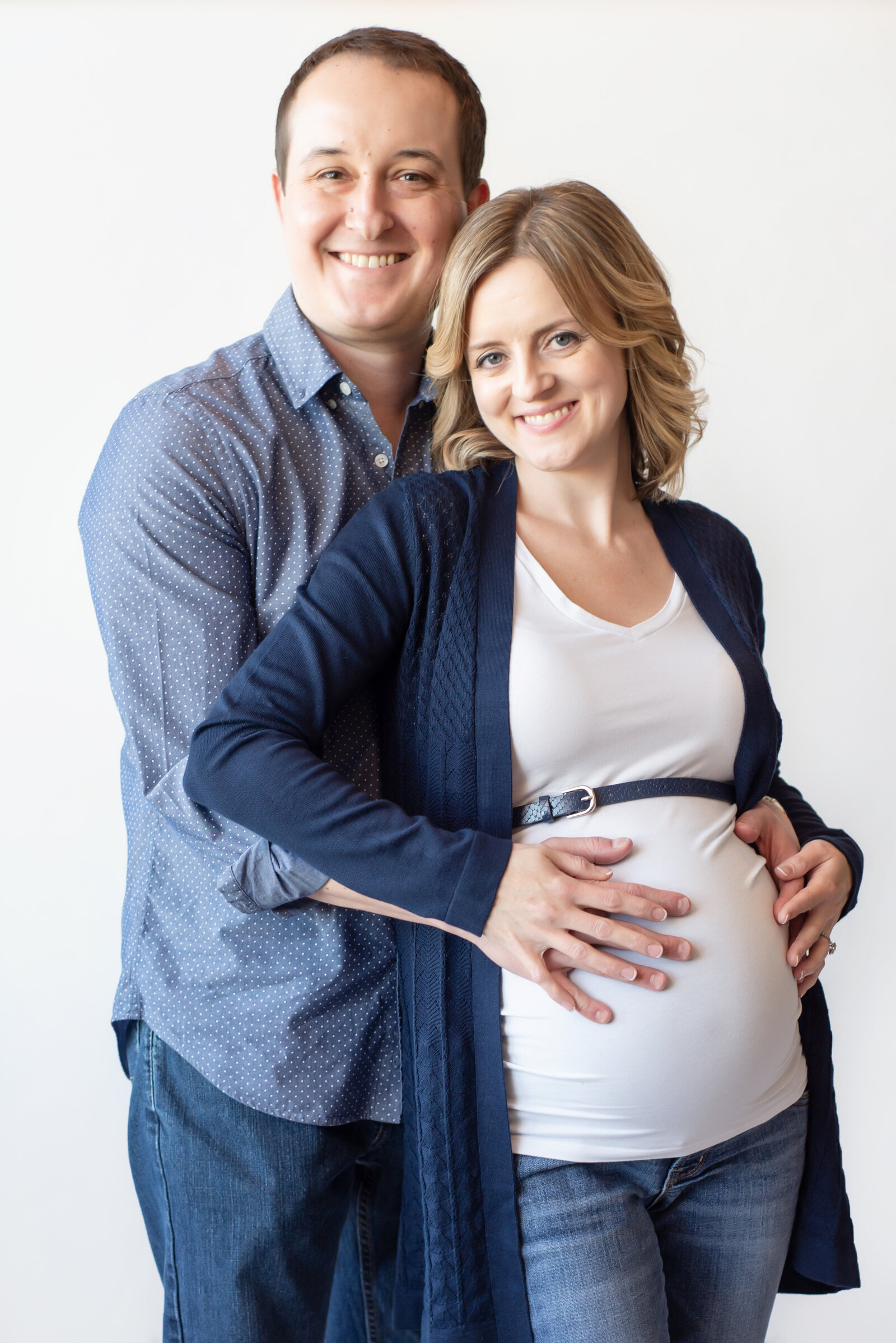 Pregnant couple in maternity photo in studio