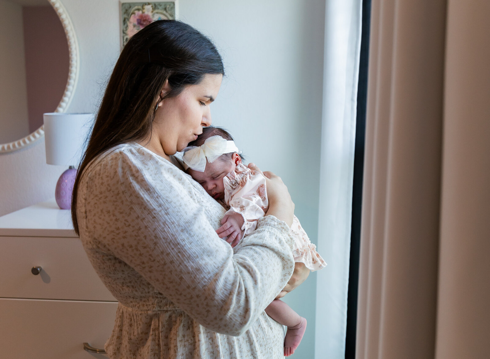mom snuggling newborn girl
