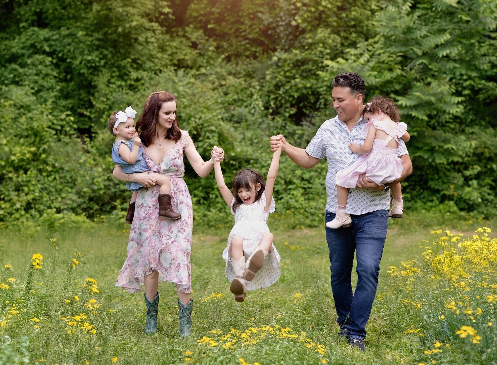 Family of 5 walking in wildflower field and singing kid in middle. Atlanta Photographer, Jenni Nikki, took this image in Canton, GA.