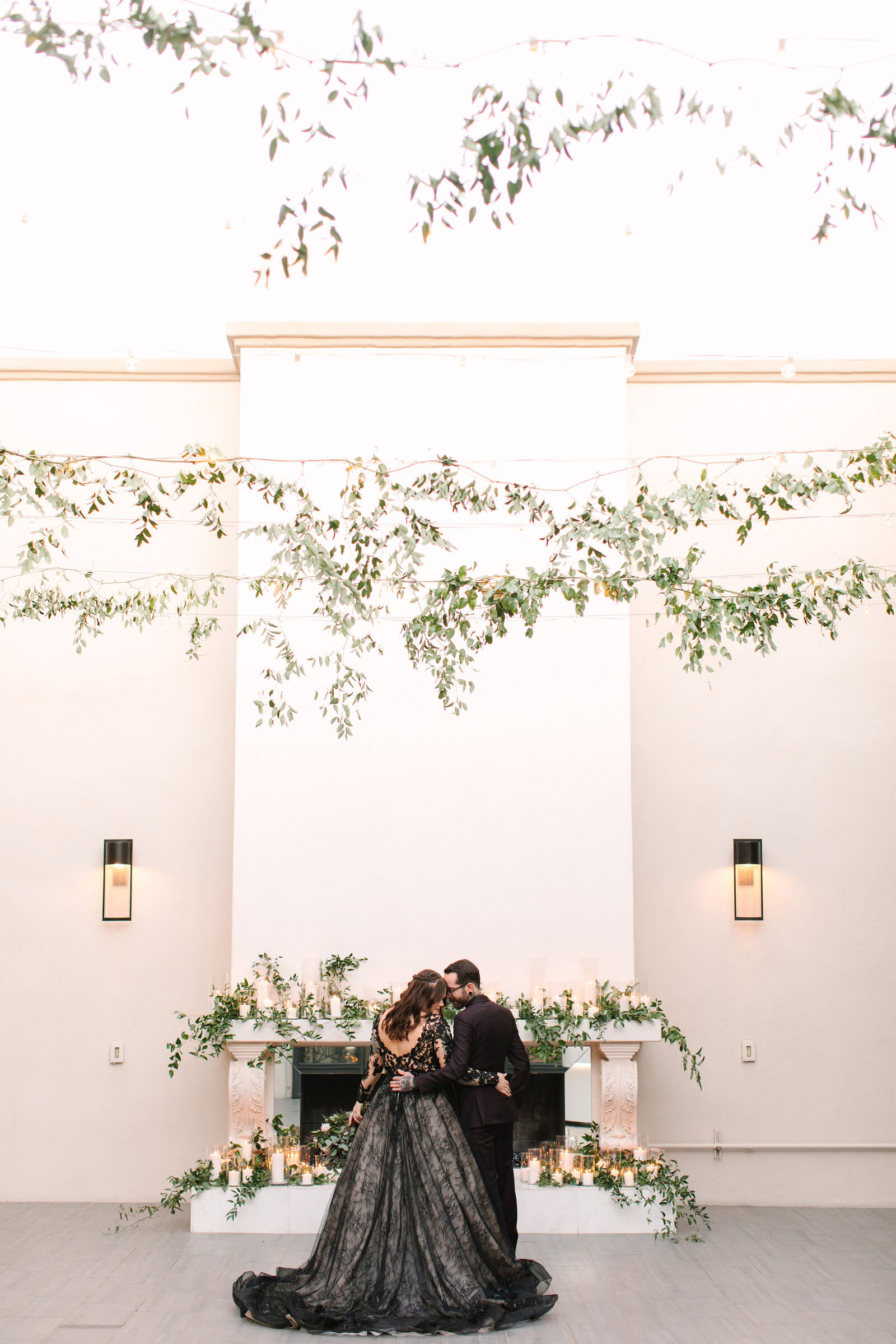 soho63-chandler-wedding-venue-bride-and-groom-fireplace-black-dress-greenery