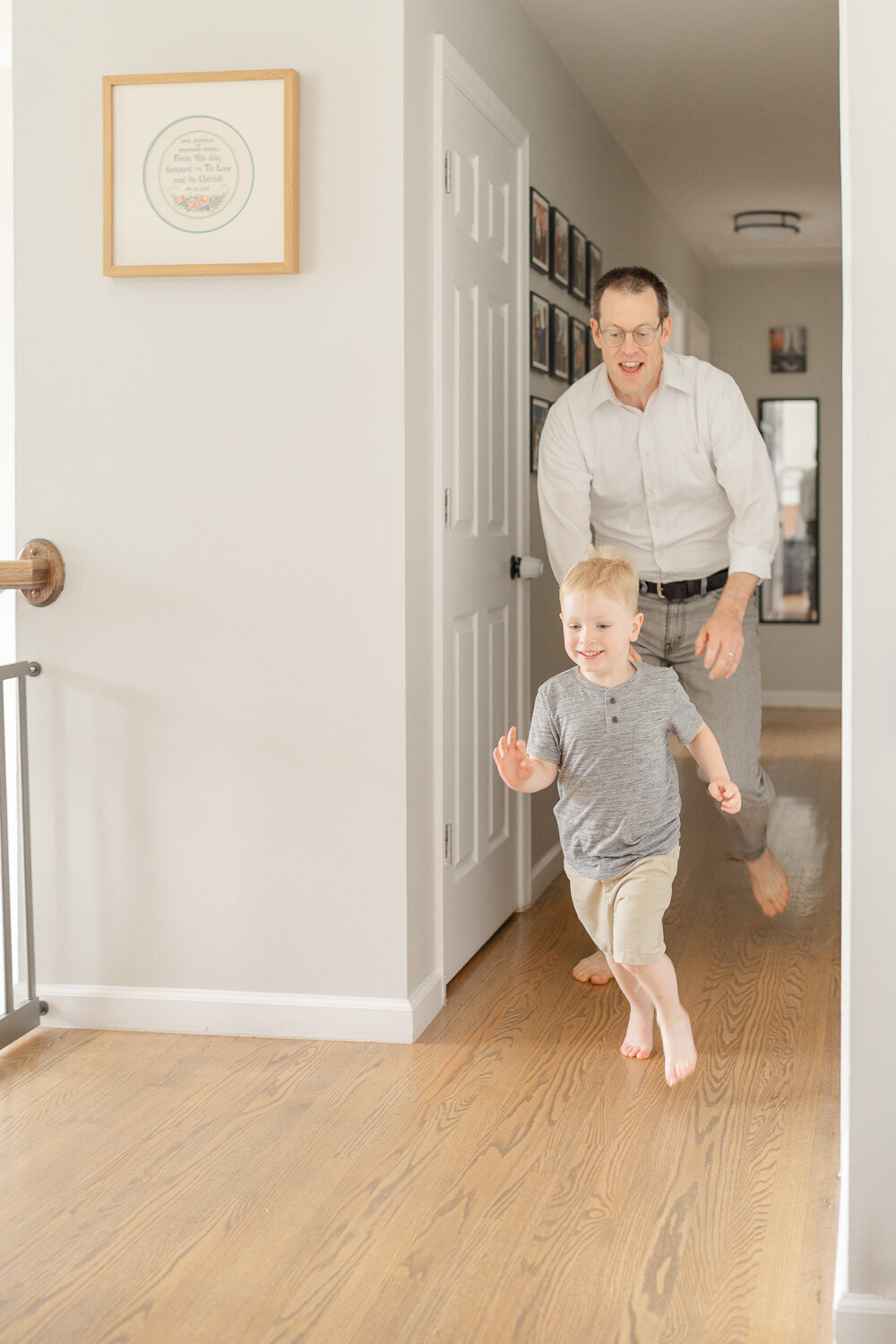 dad chasing big brother during newborn session in McLean, Virginia