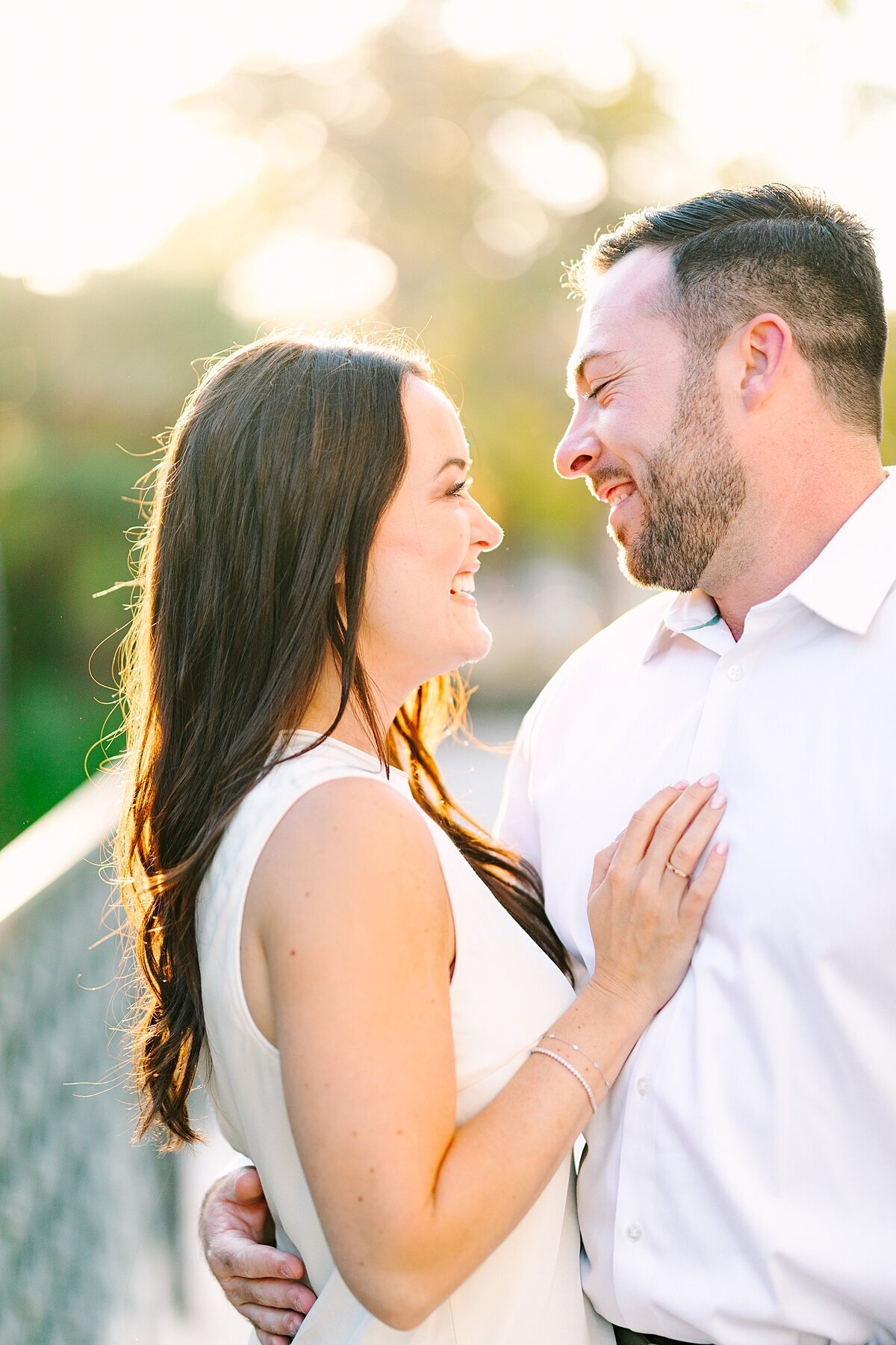 Couple smiling at each other happily as golden hour sets in in San Diego.