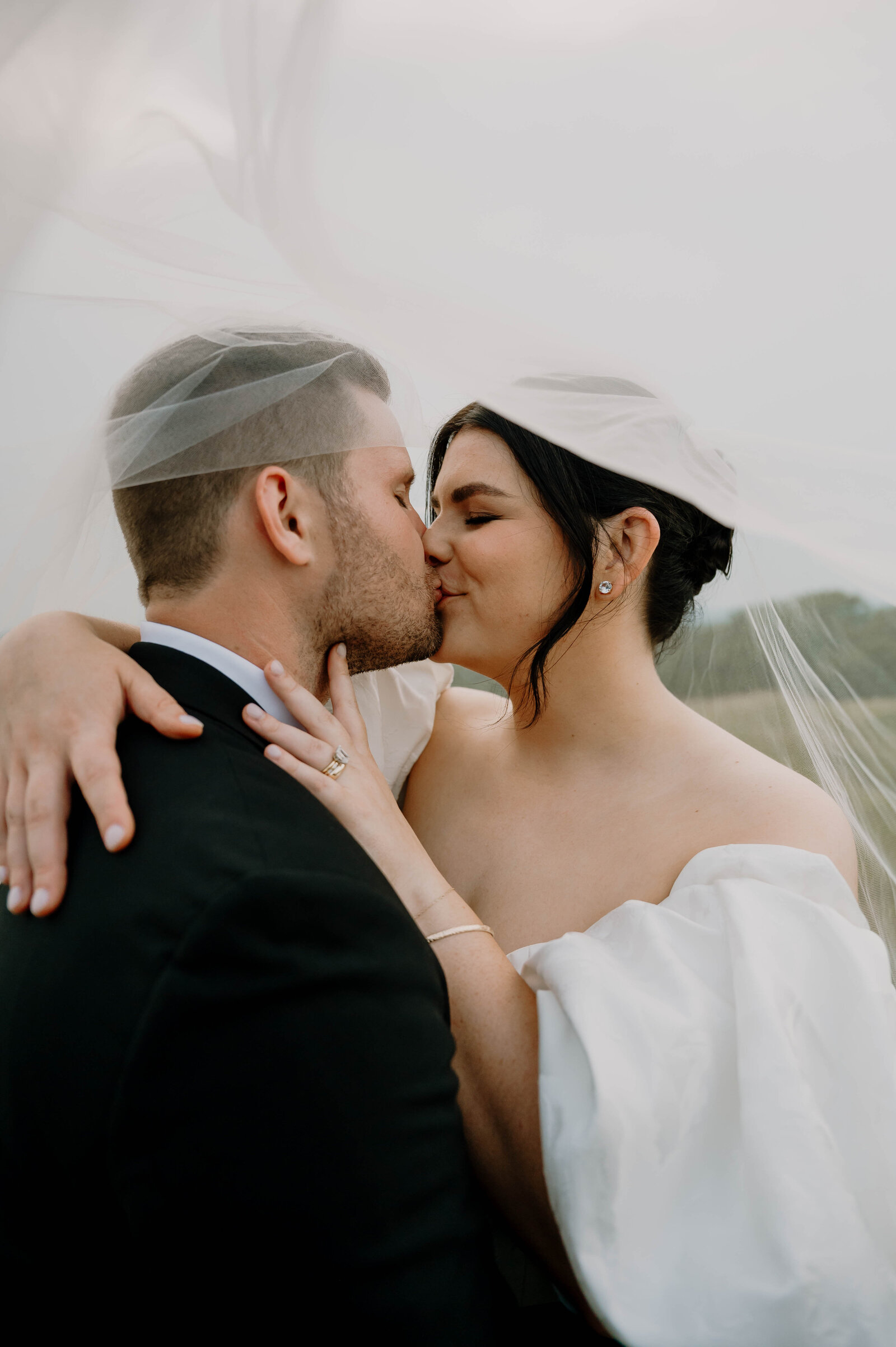 Bride and Groom kissing underneath her veil during their Massachusetts spring wedding 