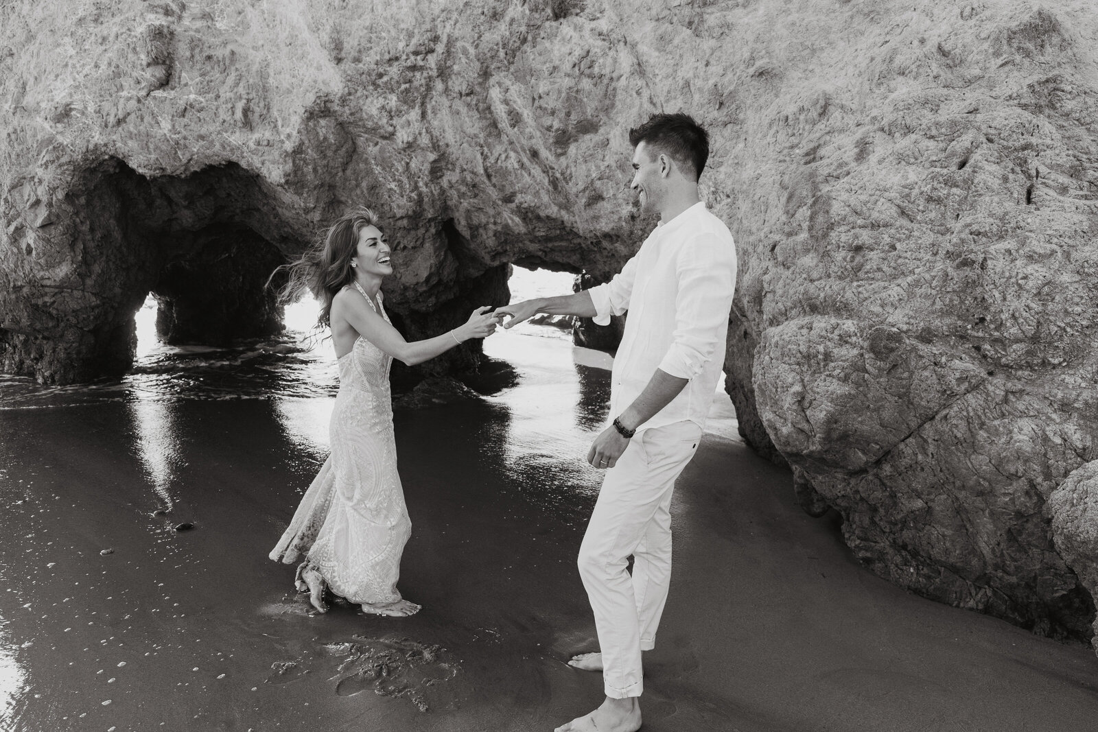 newlyweds romantic dance on malibu beach near sea cliffs
