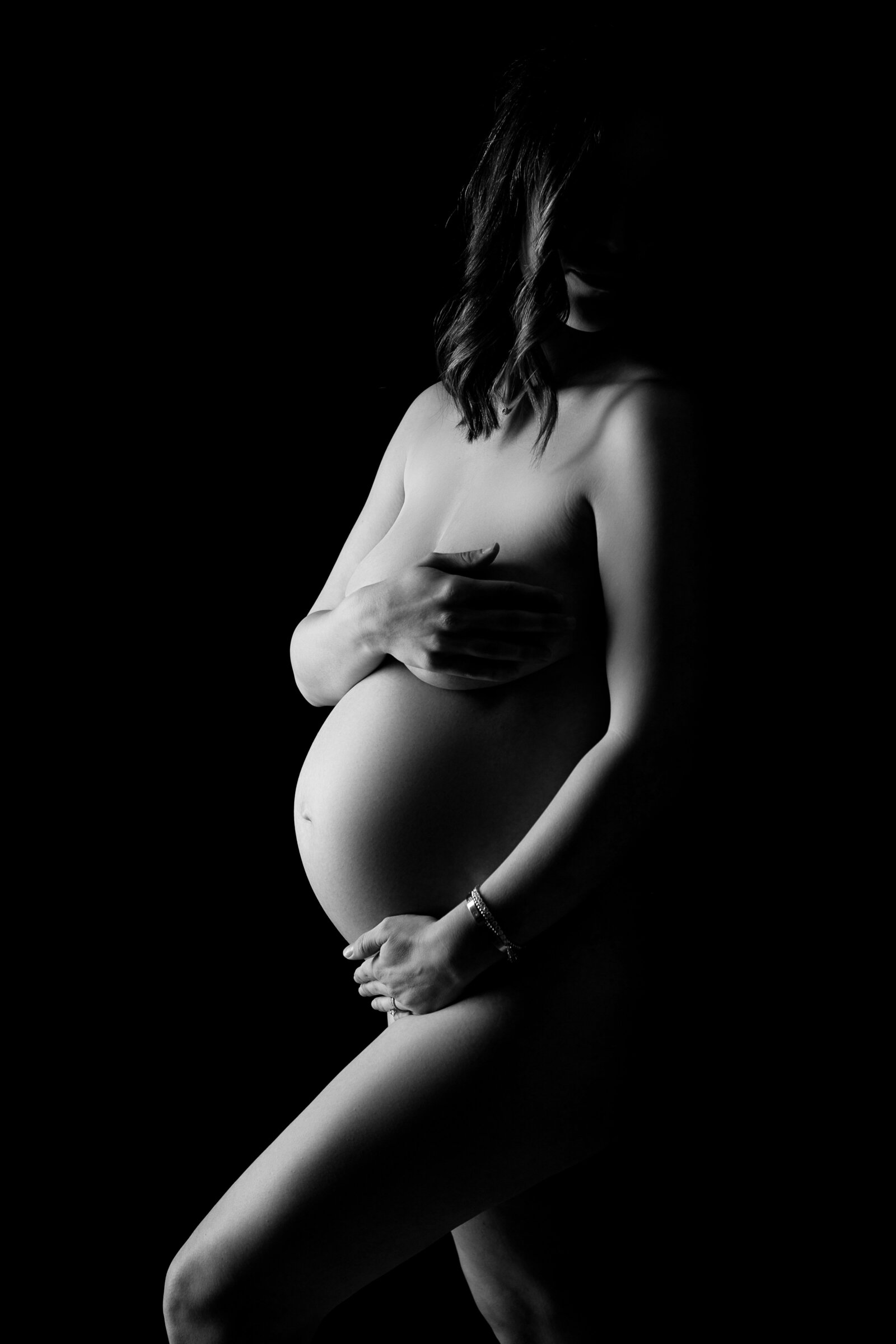 black and white maternity portrait in fresno, clovis, california. expectant mother holding belly that shows skin, tasteful, timeles, classic pregnancy photos