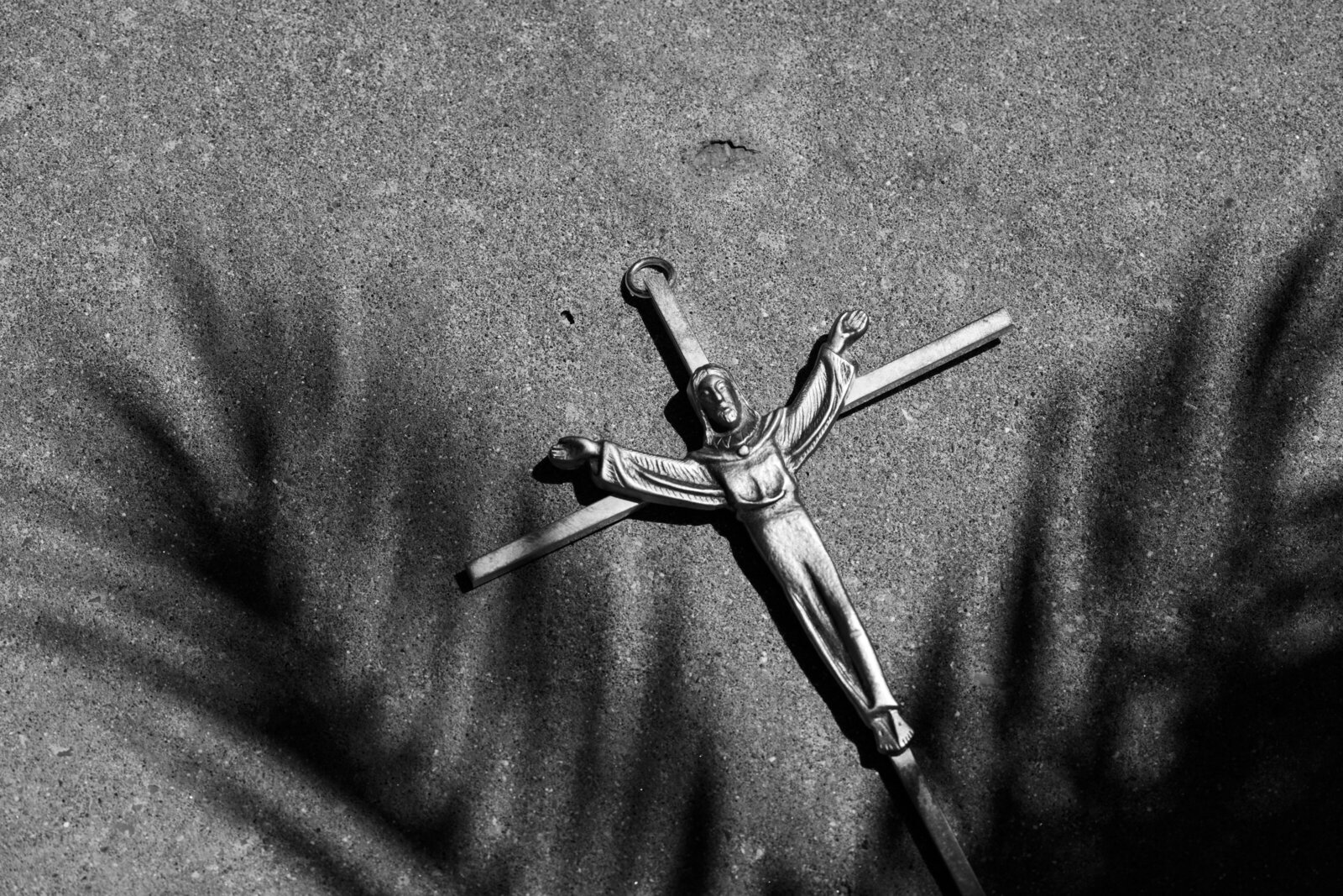 Catholic wedding accessory. Jesus on the cross with palm leaf shadows on it.