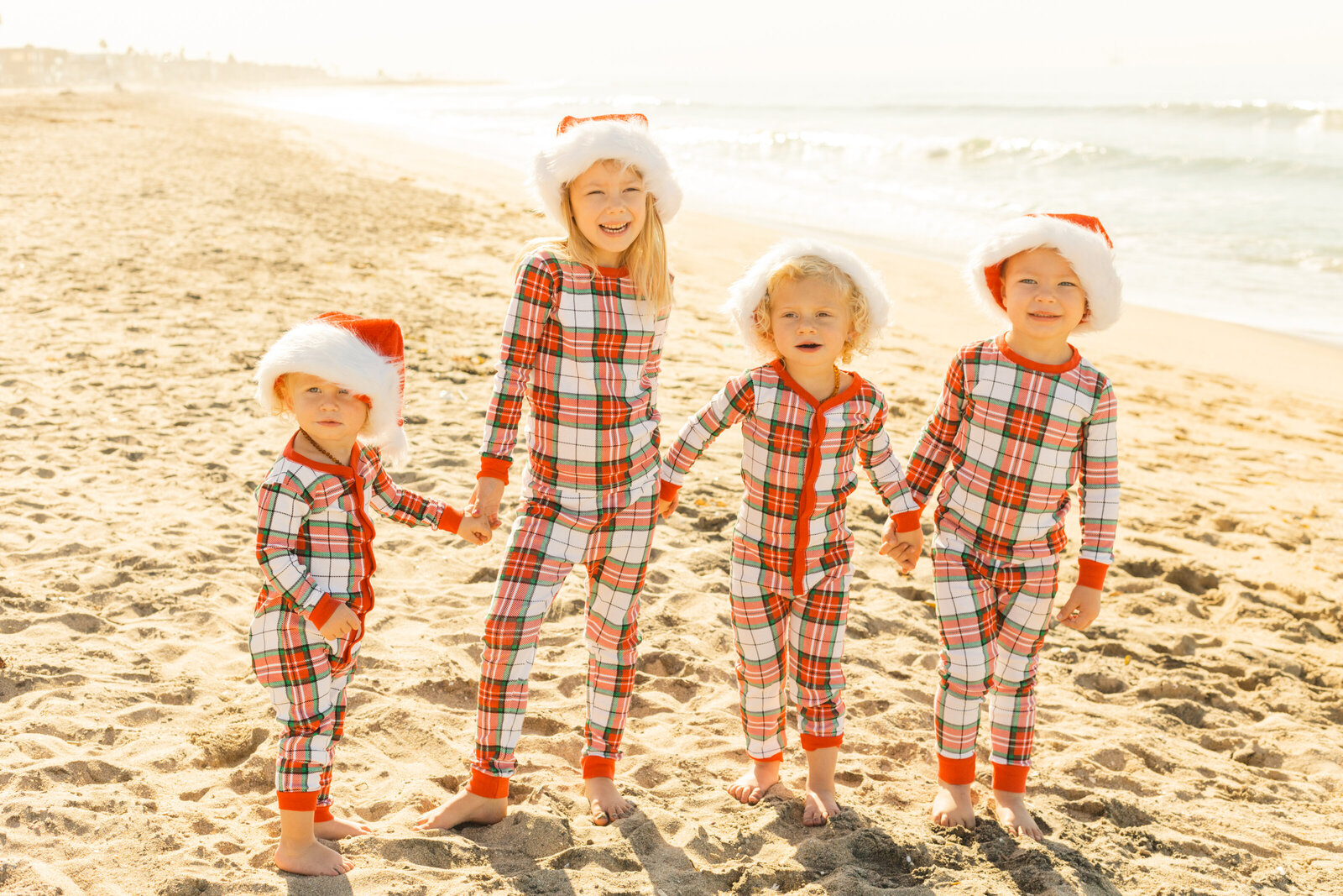 A family poses for photos on a beach wearing Christmas pajamas in Los Angeles, Ca.